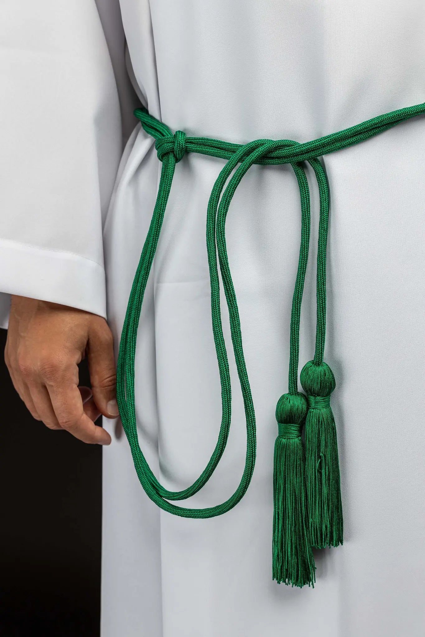 Green liturgical cincture with decorative tassels, made from braided cord.