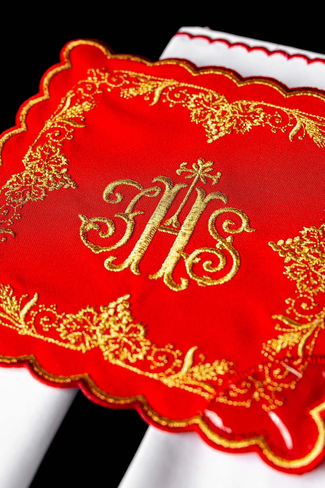 Red chalice linen set with gold IHS embroidery, including a pall, corporal, purificator, and lavabo towel.