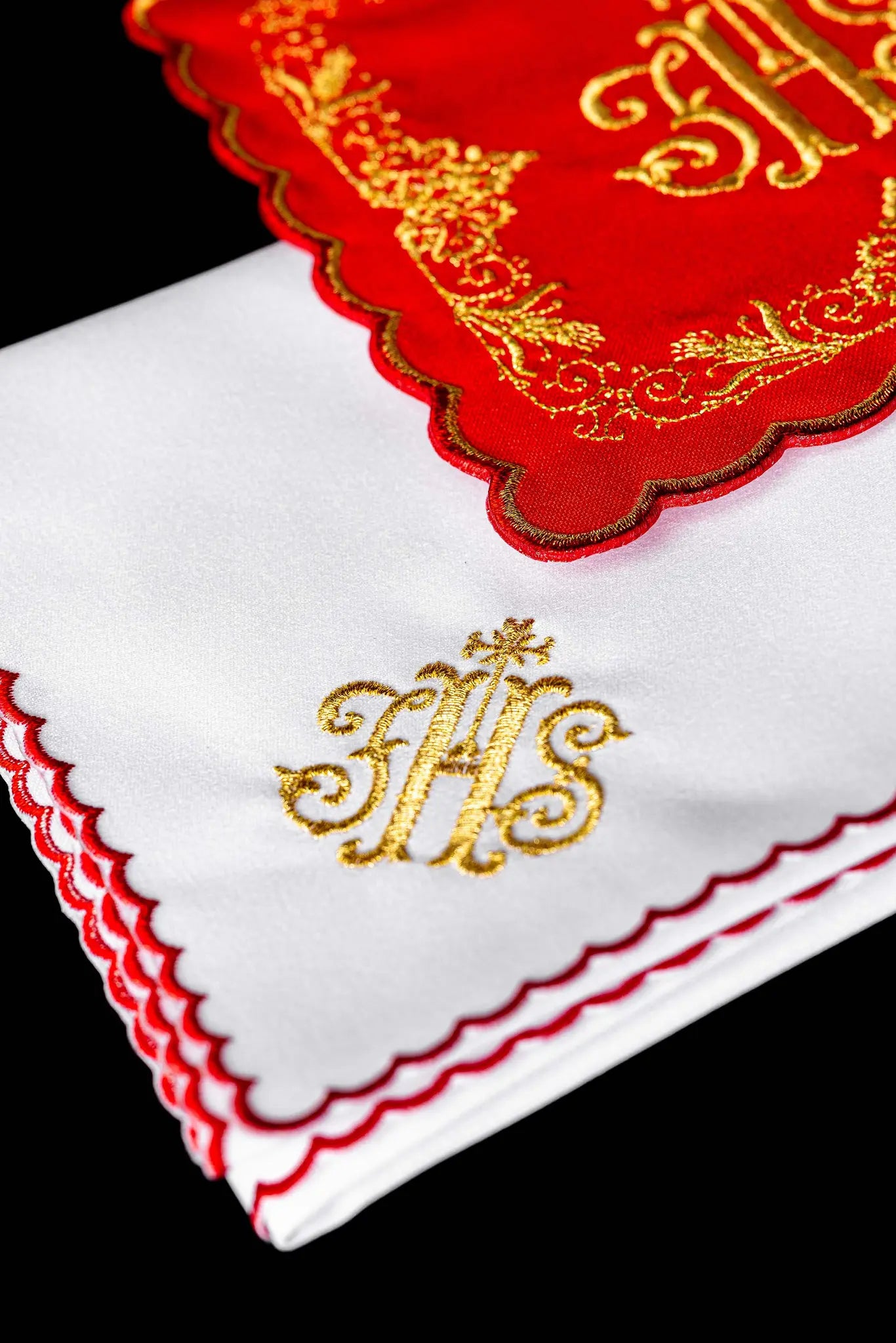 Red chalice linen set with gold IHS embroidery, including a pall, corporal, purificator, and lavabo towel.