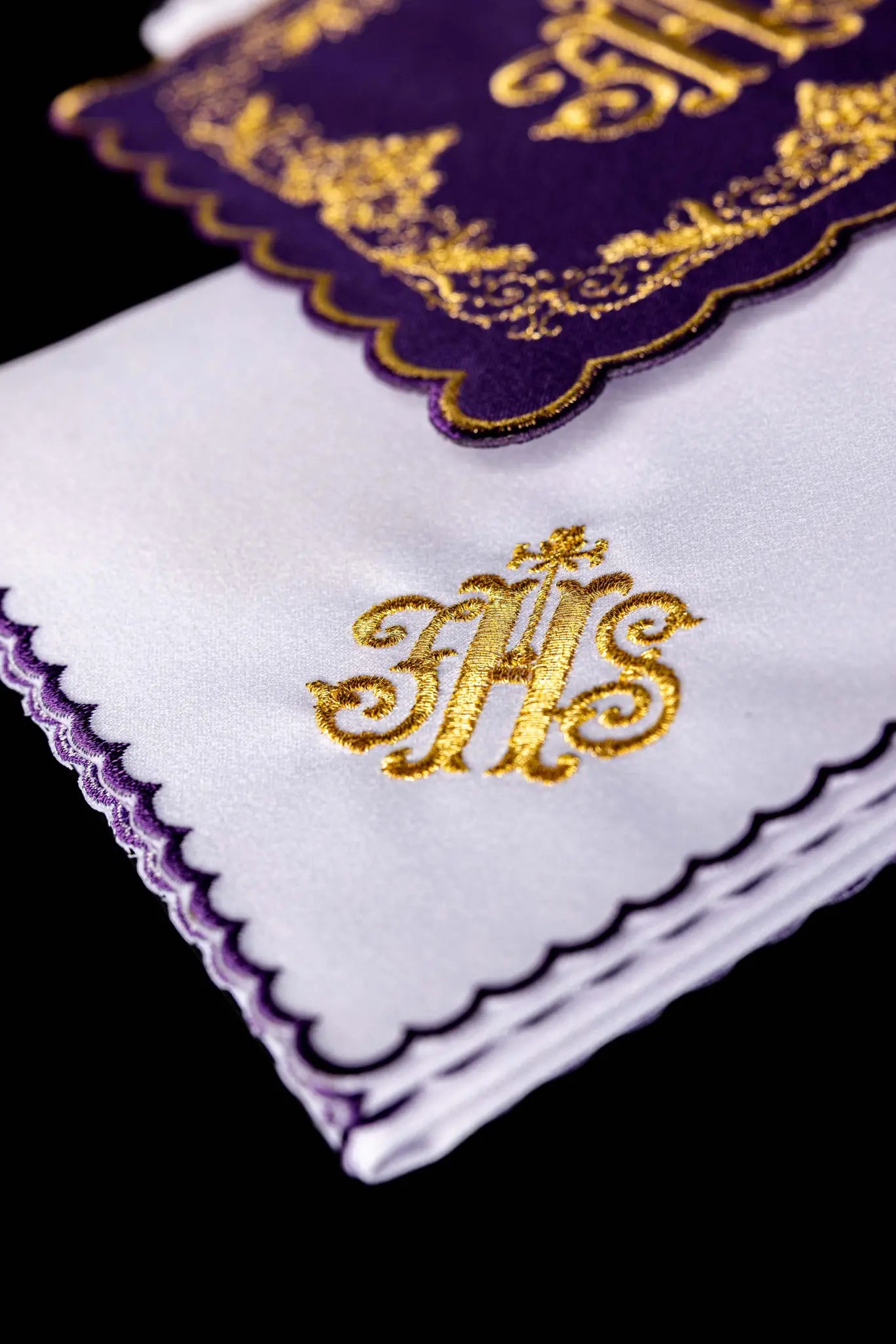Purple chalice linen set with gold IHS embroidery, vine leaves, and wheat sheaves. Includes a purple pall, white corporal with IHS, and white purificator and lavabo towel with gold crosses and purple scalloped edges.