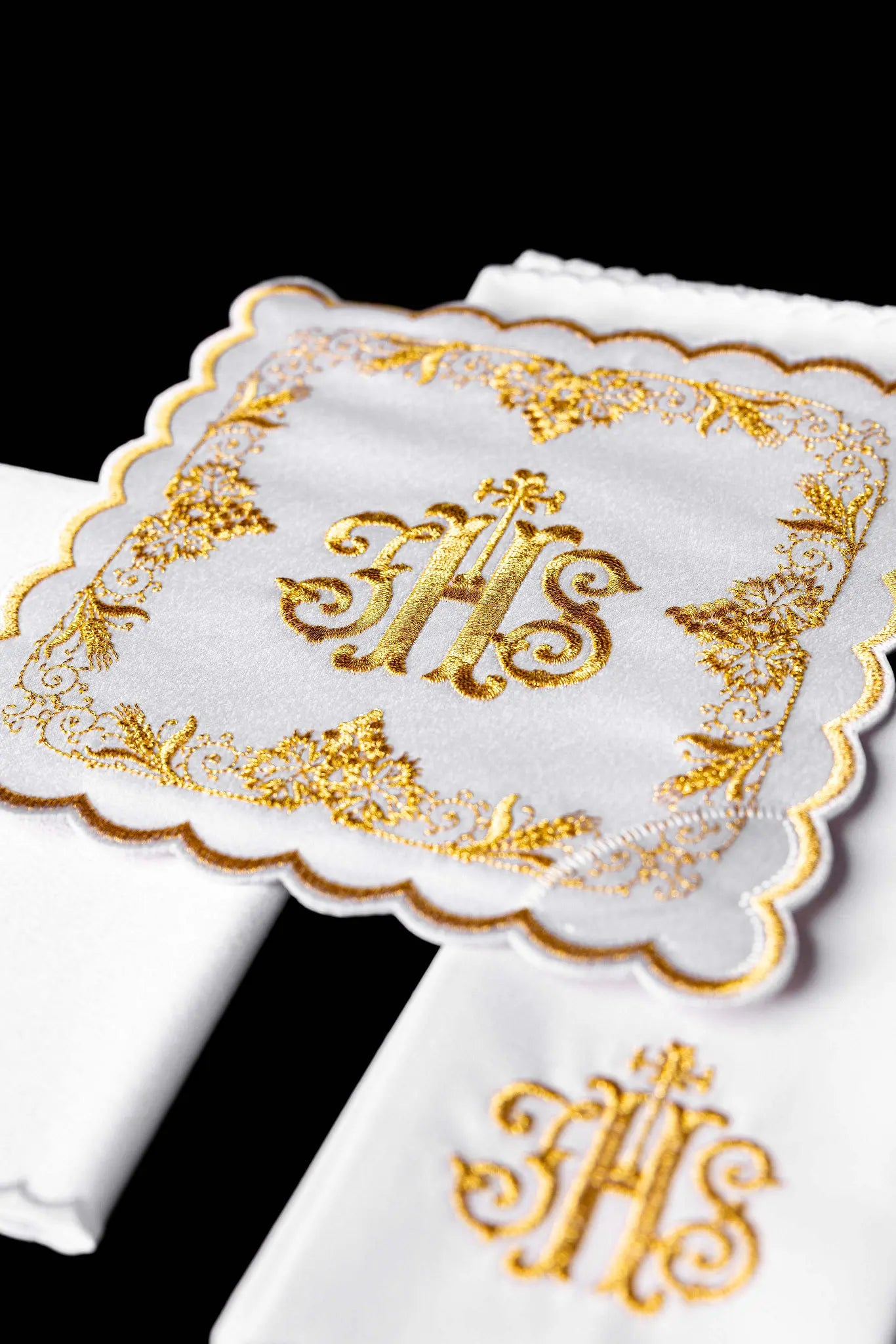 White chalice linen set with IHS embroidery on pall, purificator, and lavabo towel.