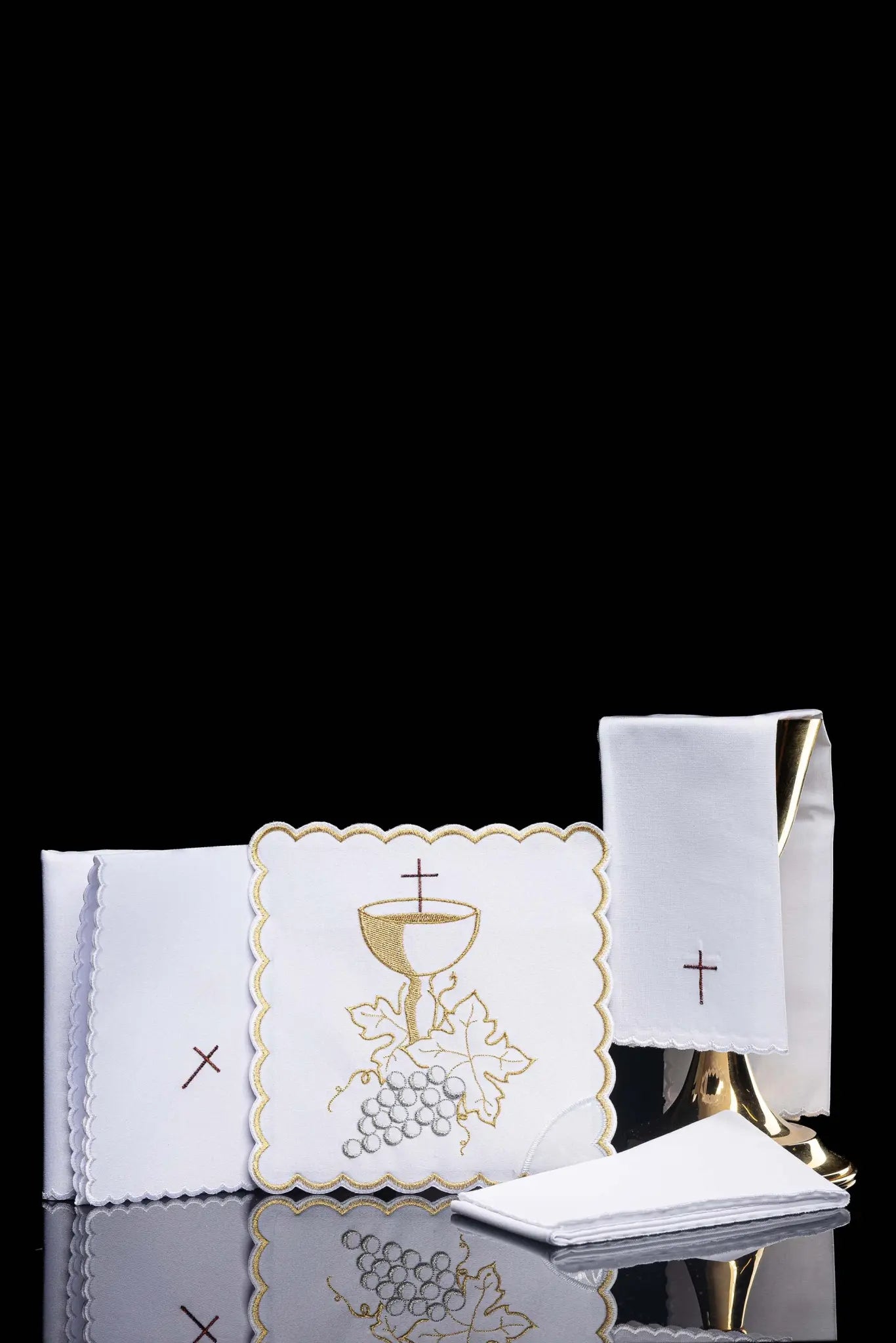 White chalice linen set with IHS monogram embroidery on the pall and cross embroidery on the purificator and lavabo towel.