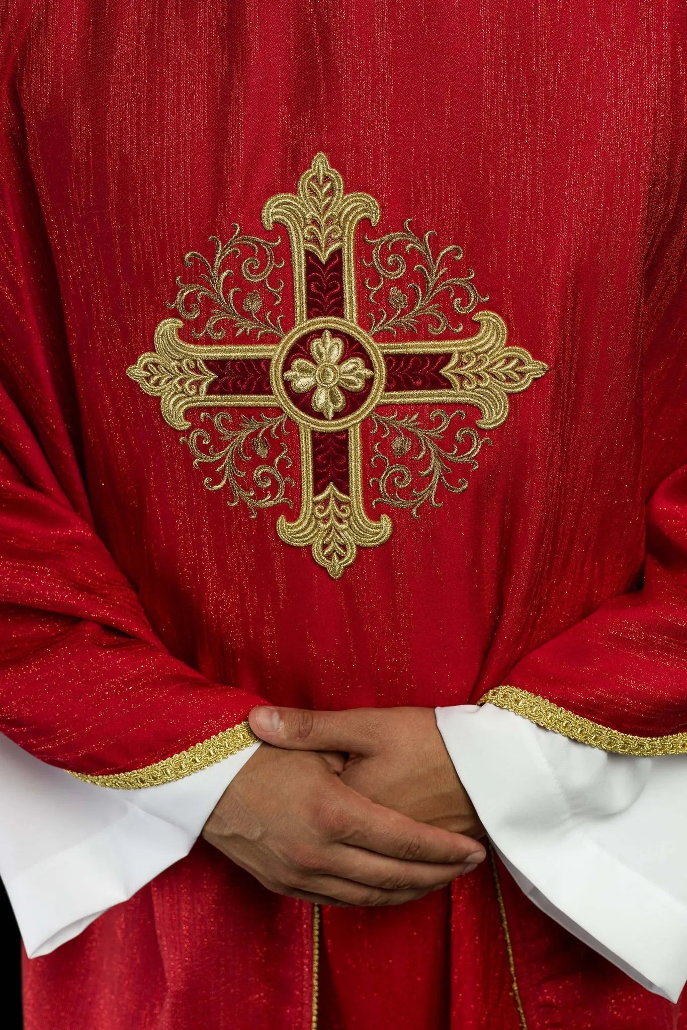 Red chasuble with embroidered cross motif on decorative fabric