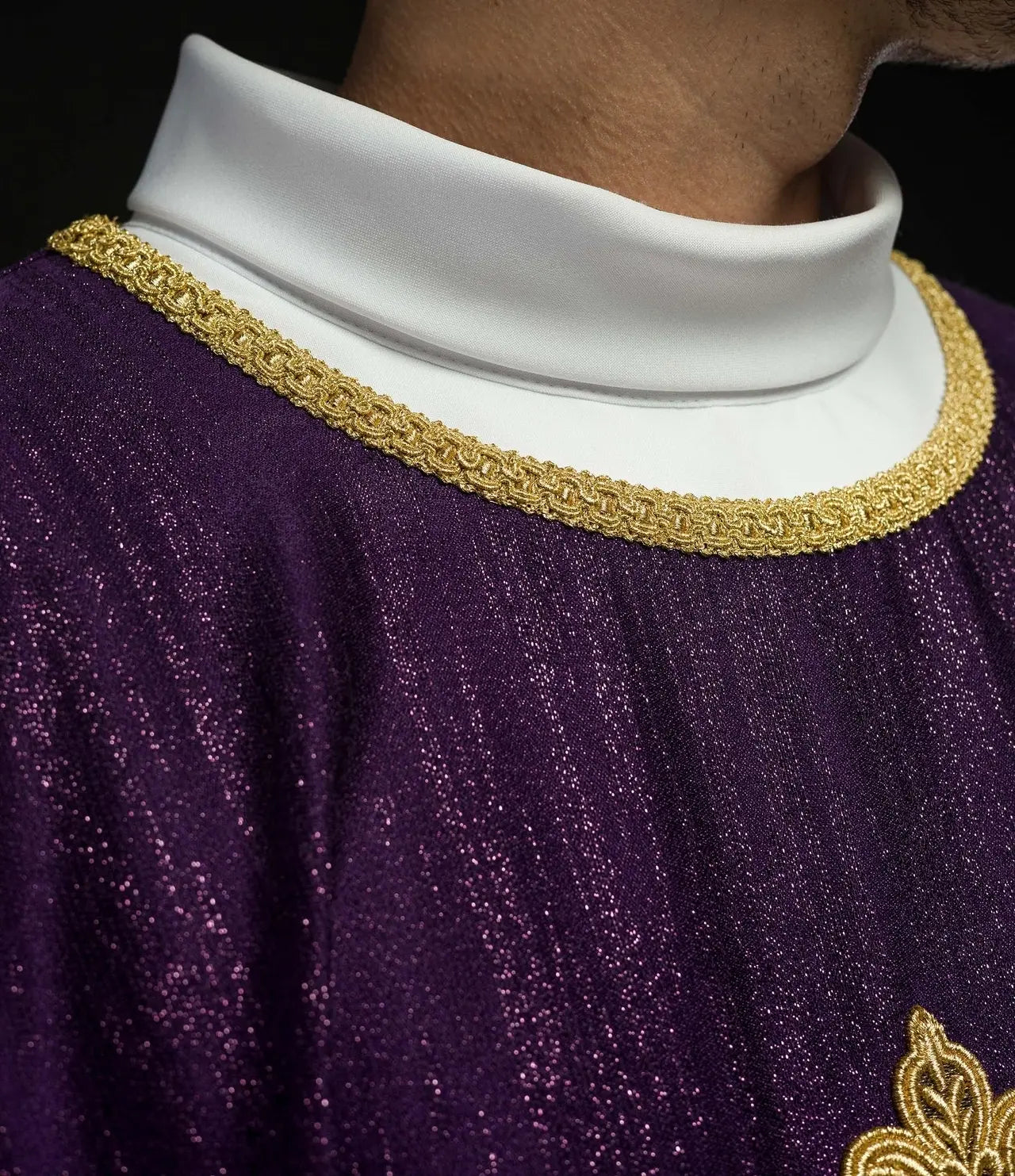Purple liturgical chasuble with an embroidered cross motif on decorative fabric