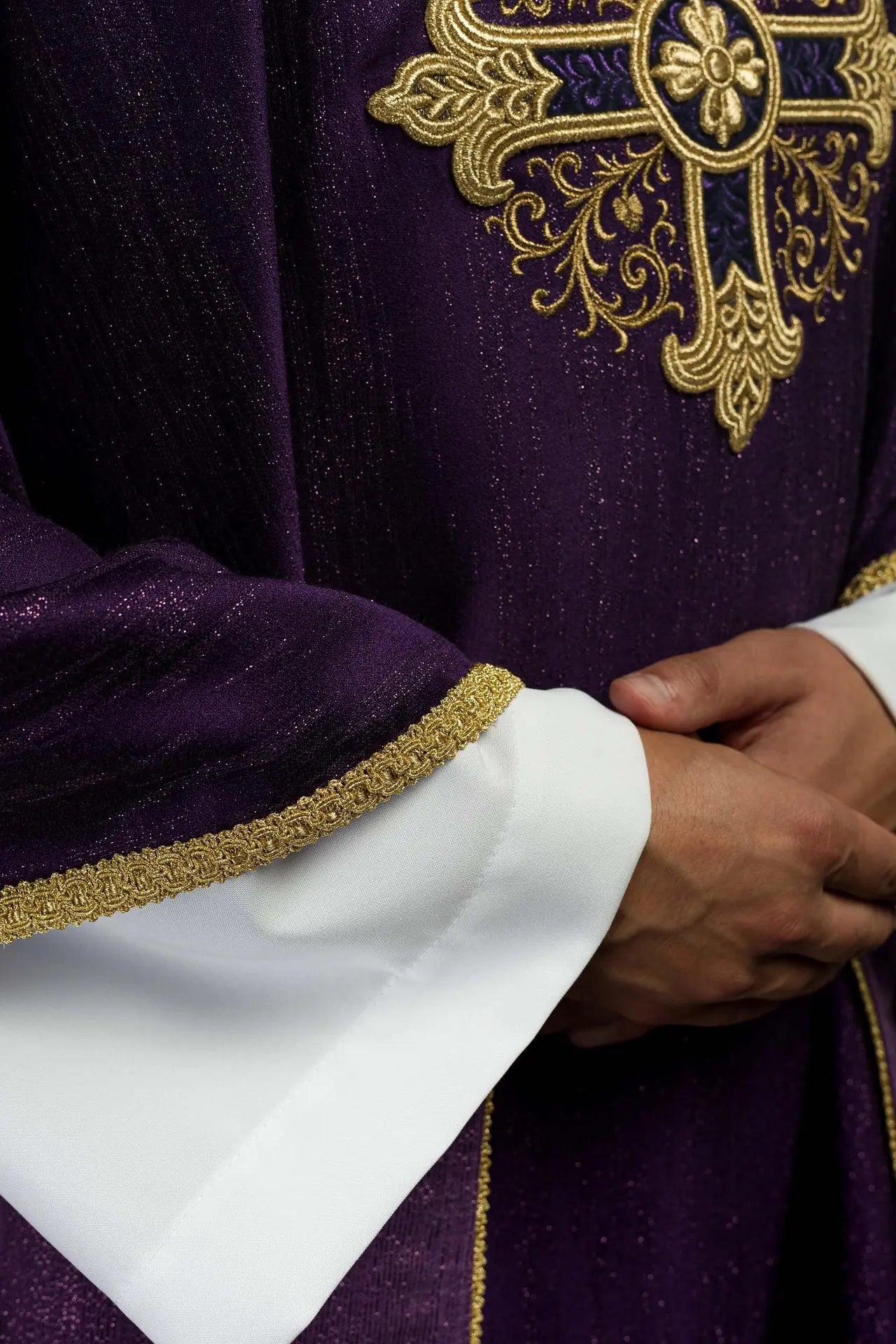 Ornat liturgiczny w kolorze fioletowym z haftowanym motywem krzyża na ozdobnej tkaninie