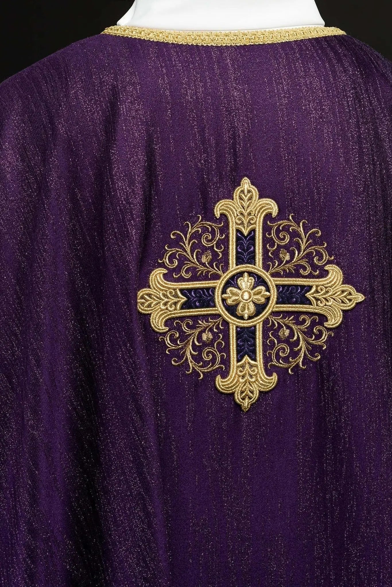 Purple liturgical chasuble with an embroidered cross motif on decorative fabric