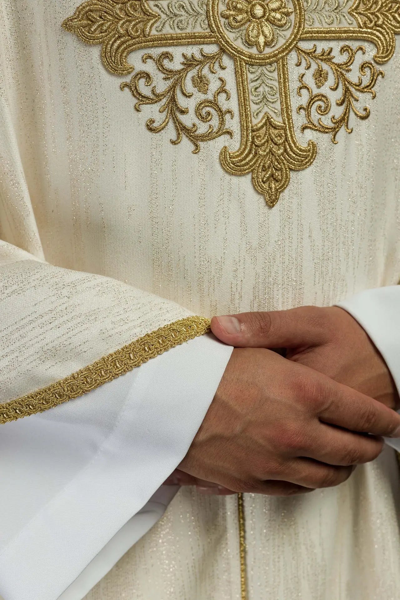Ecru chasuble with embroidered cross motif on decorative fabric