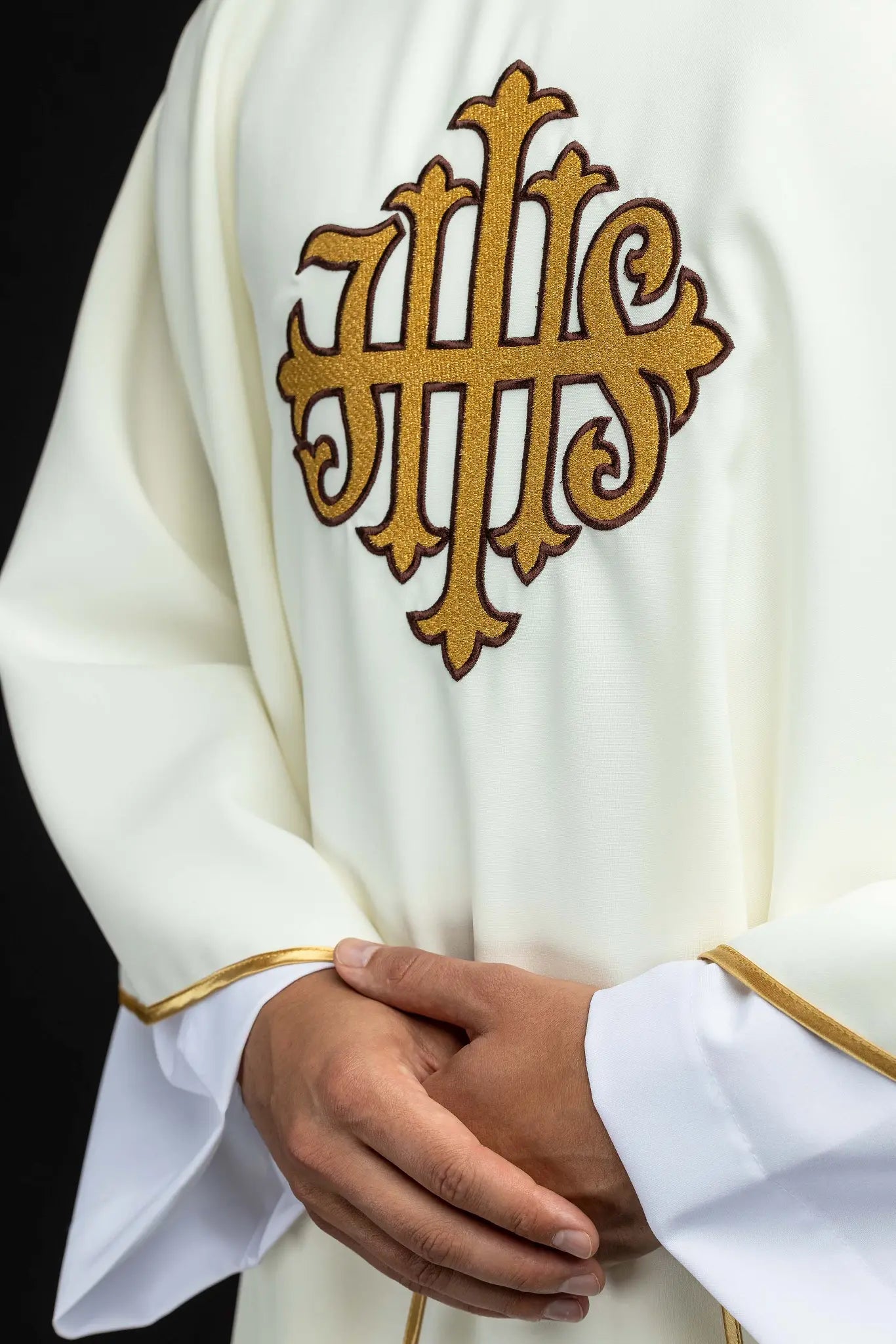 Ecru chasuble with gold IHS embroidery and gold trim, featuring a V-neck collar.