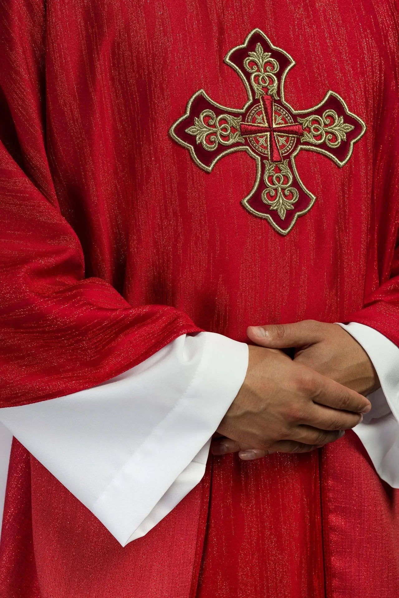 Czerwony ornat z haftowanym motywem krzyża na dekoracyjnej tkaninie