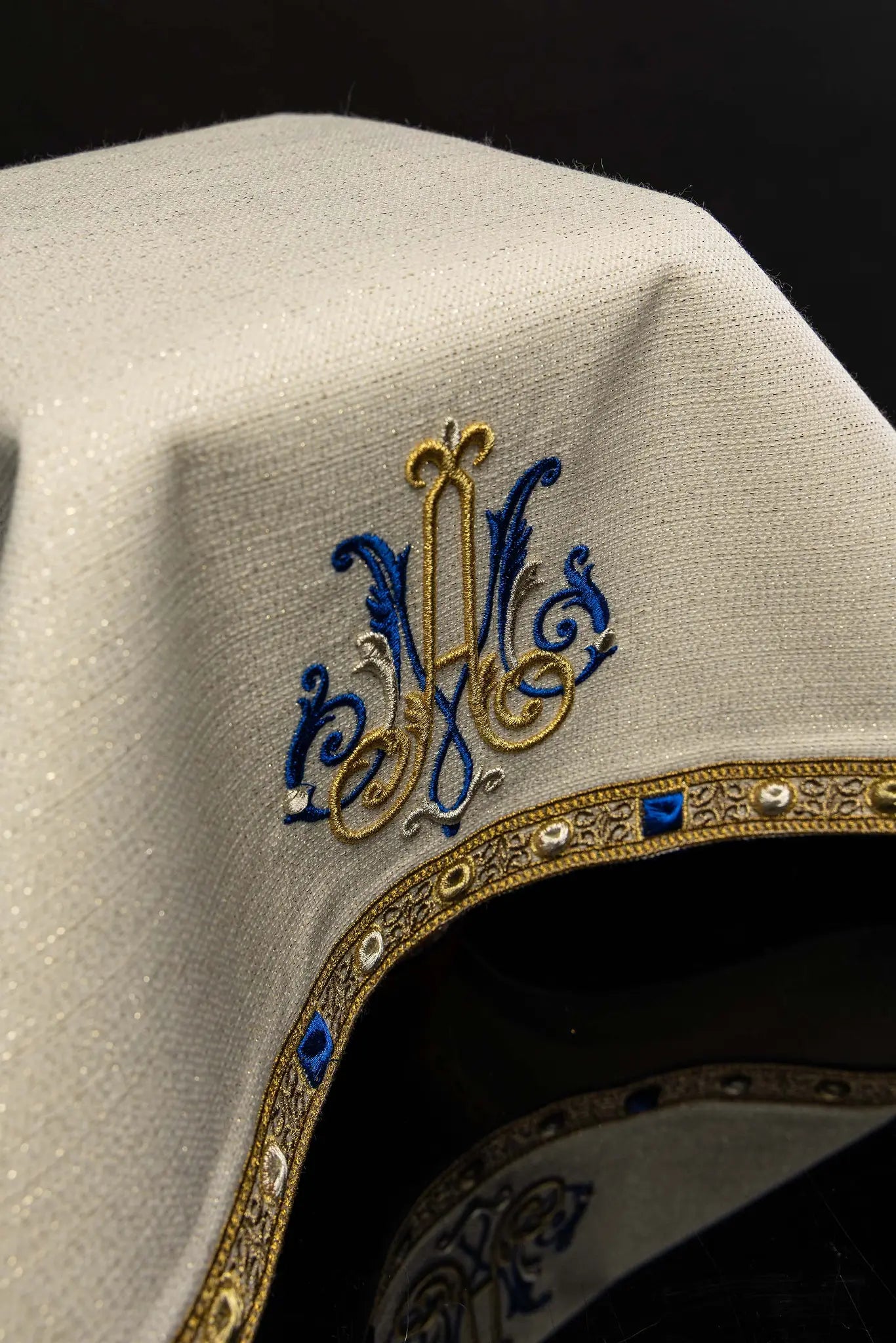 Ecru chalice veil with Marian embroidery in gold, blue, and silver, featuring a decorative gold trim with blue and pearl-like details.