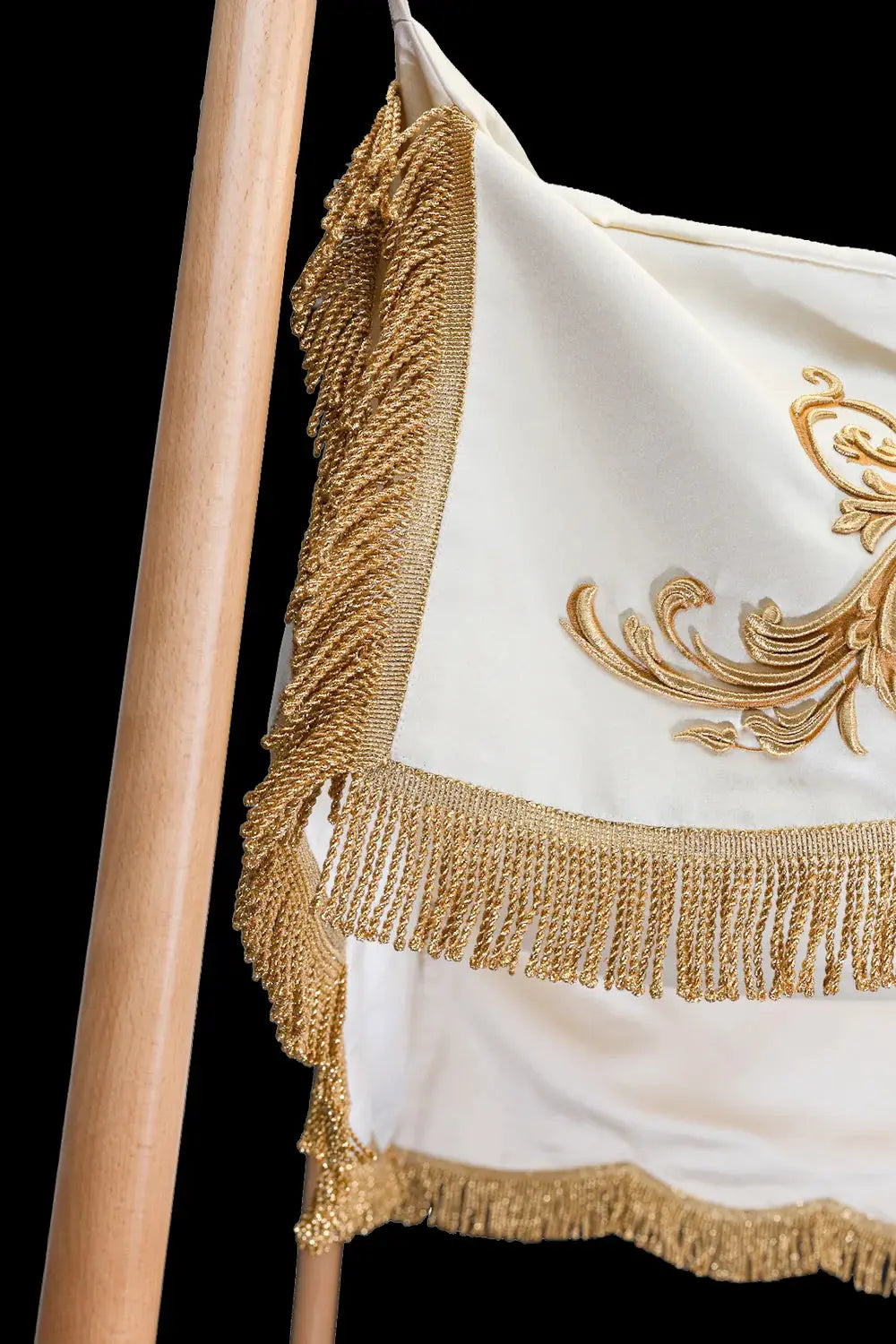 White baldachin with gold fringe and corner trim, close-up view