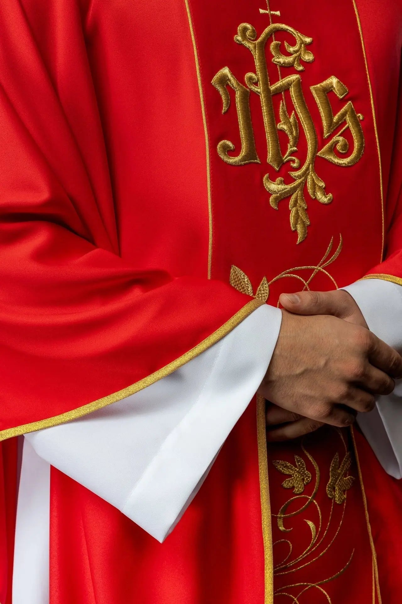 Czerwony ornat liturgiczny z bogato zdobionym pasem z motywem kwiatowym i IHS