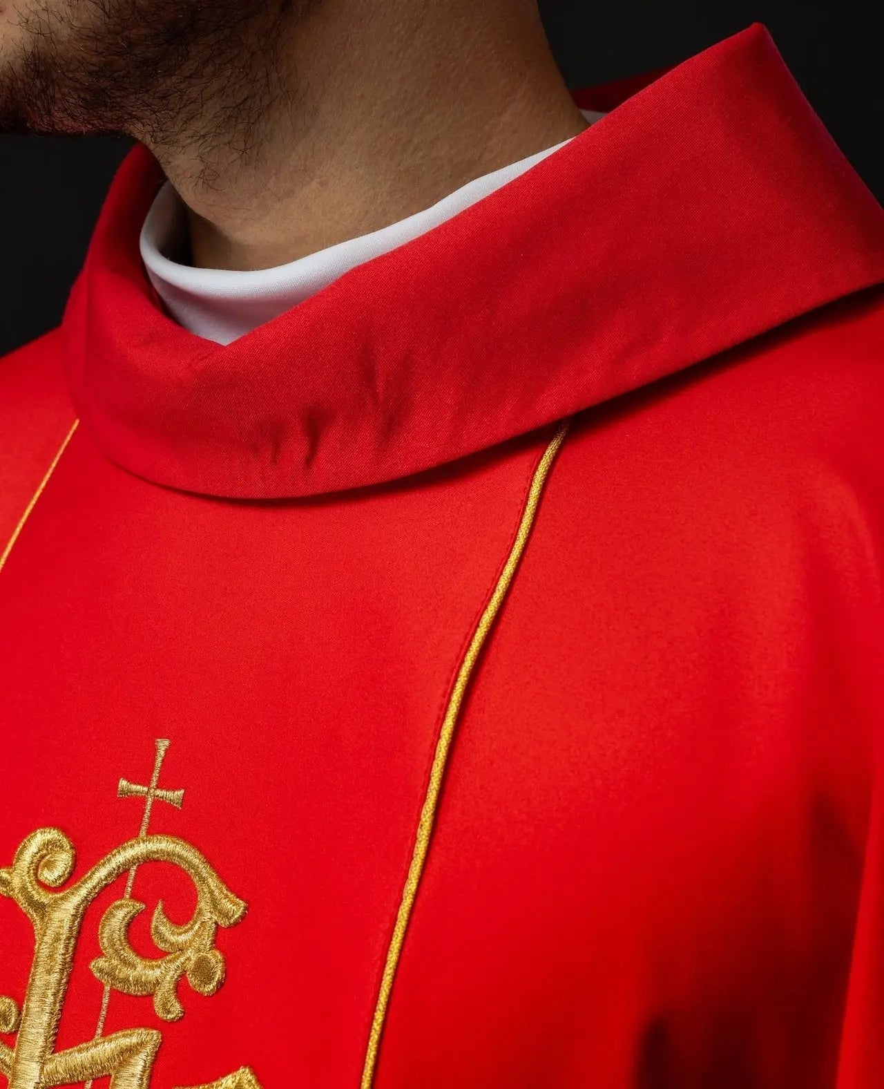 Czerwony ornat liturgiczny z bogato zdobionym pasem z motywem kwiatowym i IHS
