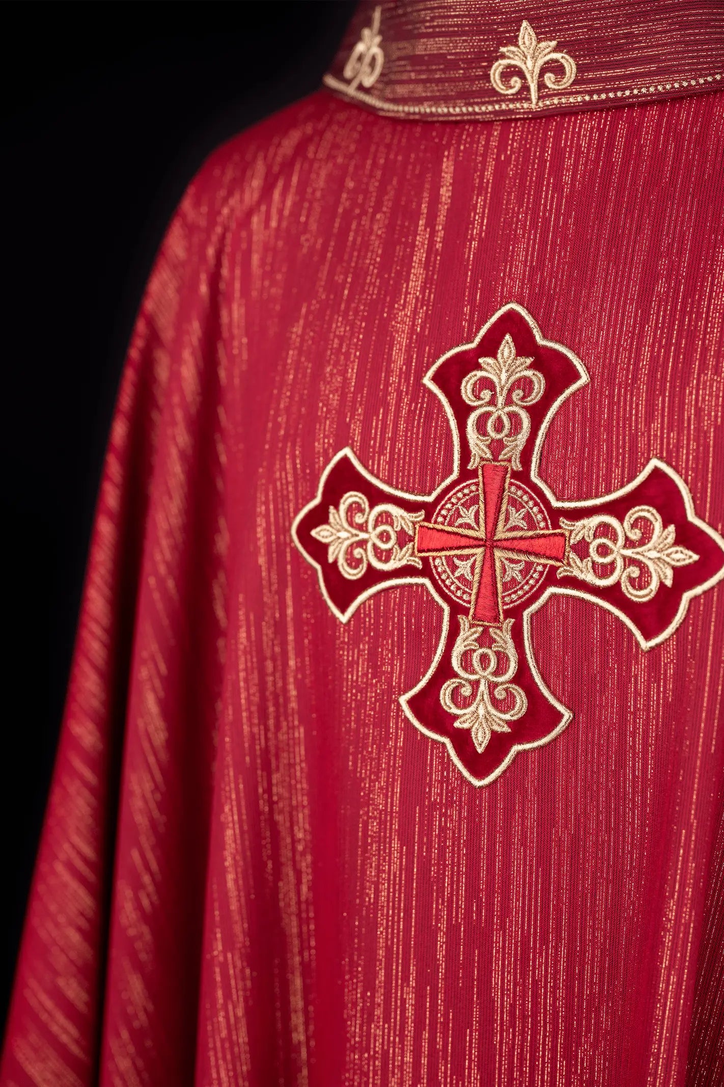 Czerwony ornat liturgiczny z bogato haftowanym krzyżem i zdobionym kołnierzem
