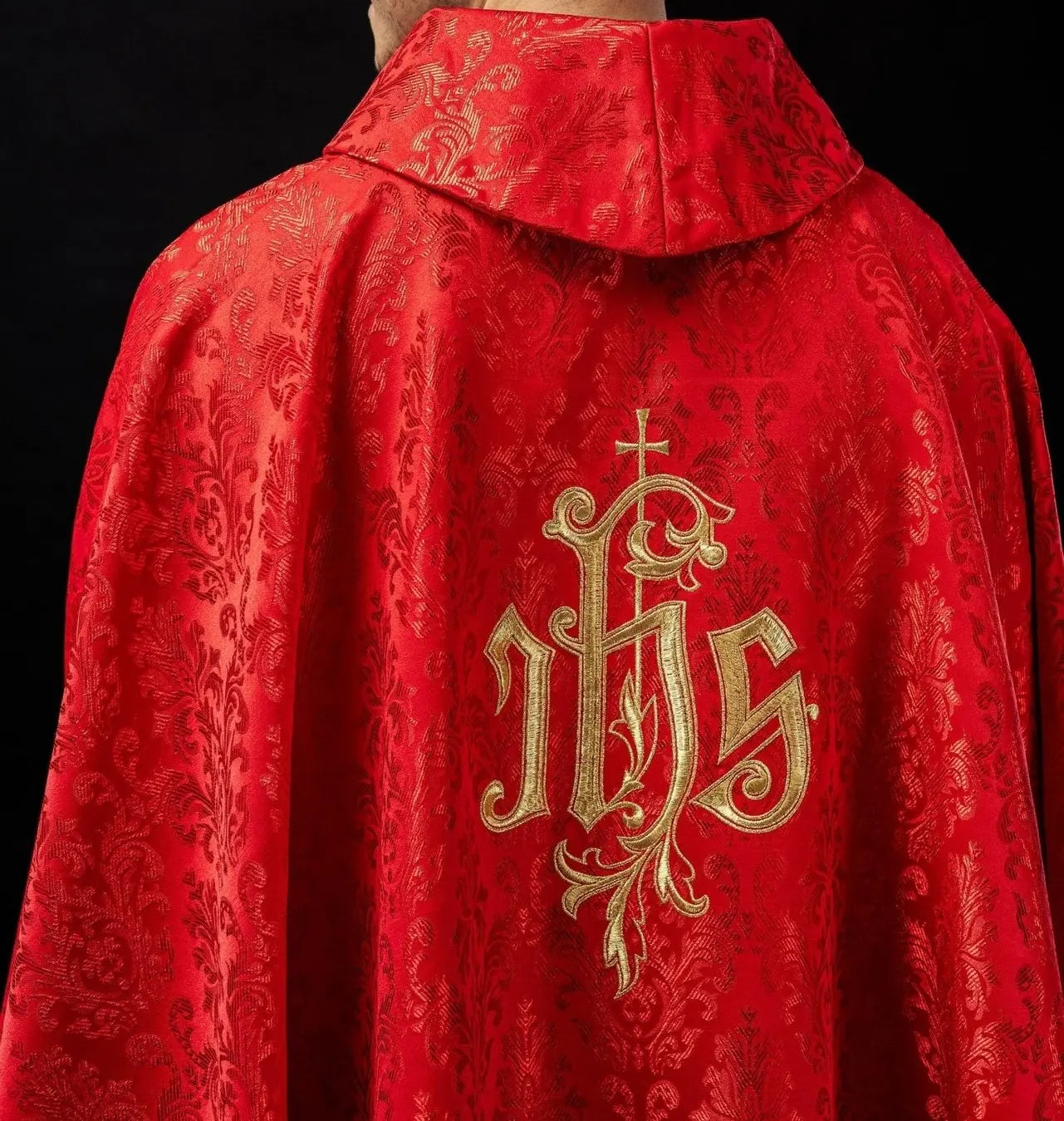 Red chasuble with embroidered IHS motif on decorative fabric