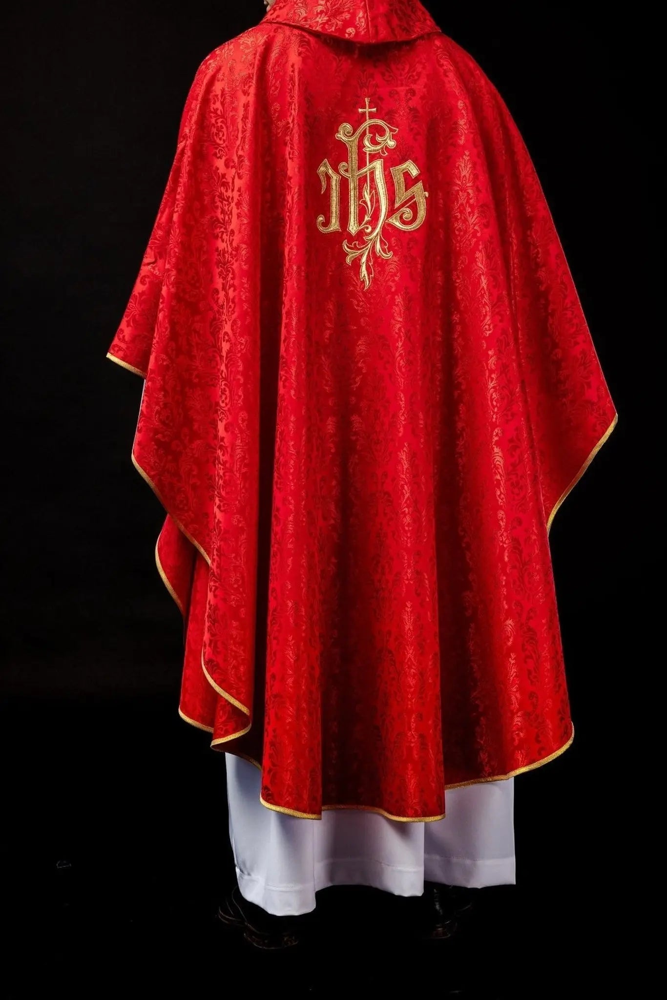 Red chasuble with embroidered IHS motif on decorative fabric