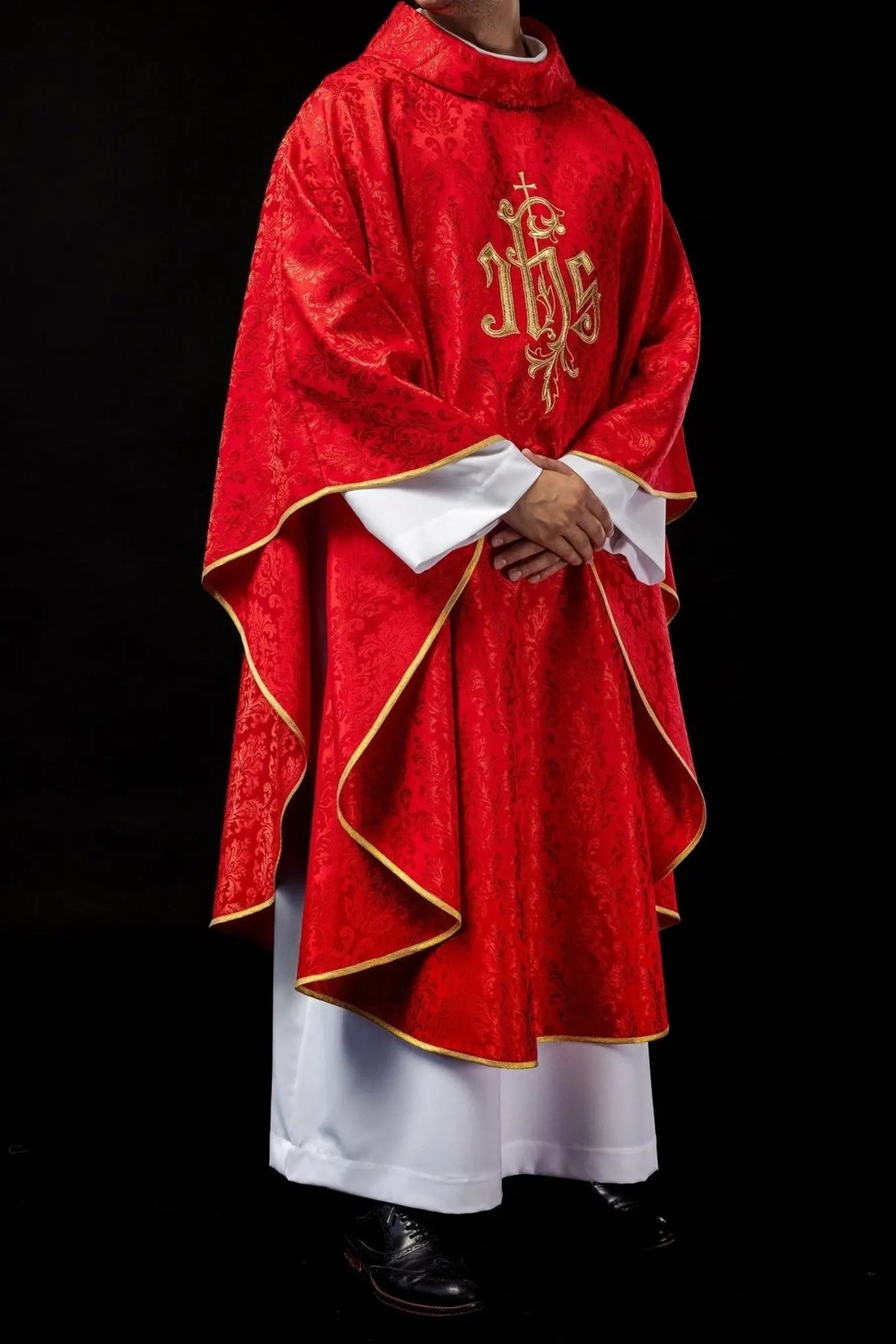 Red chasuble with embroidered IHS motif on decorative fabric