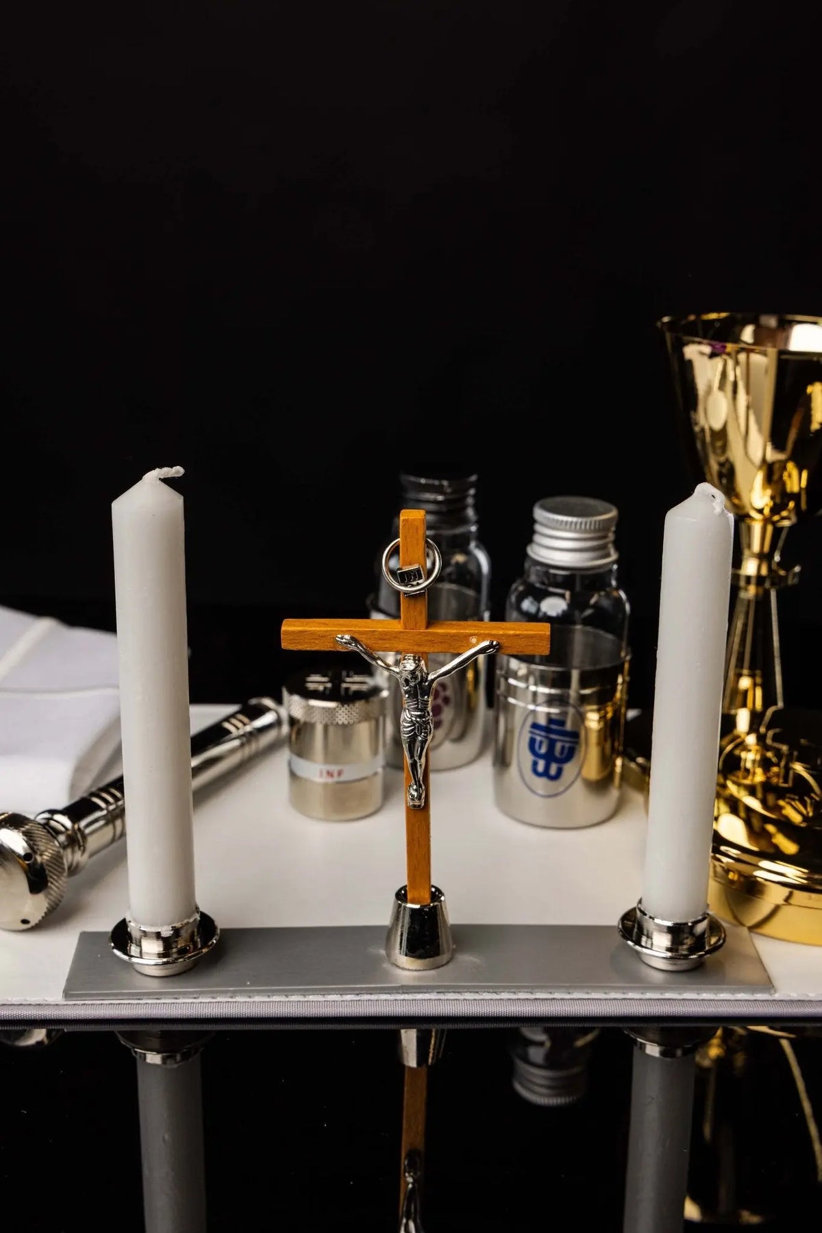 Czarna walizka liturgiczna, krzyż, świece i naczynia, widok z przodu