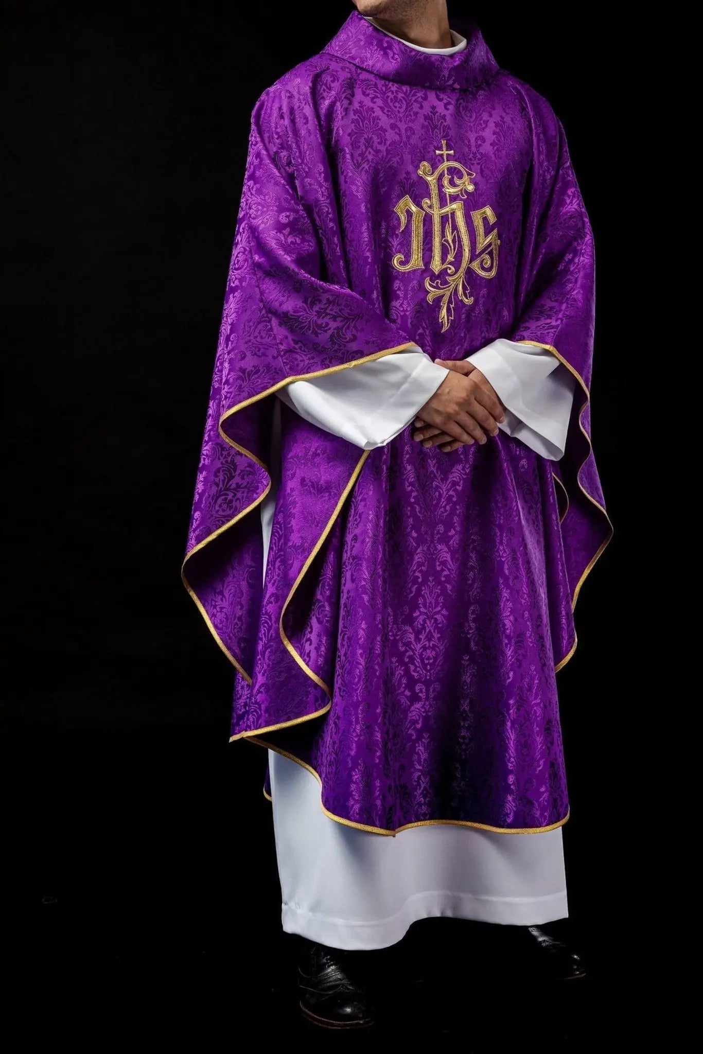 Purple chasuble with embroidered IHS motif on decorative fabric