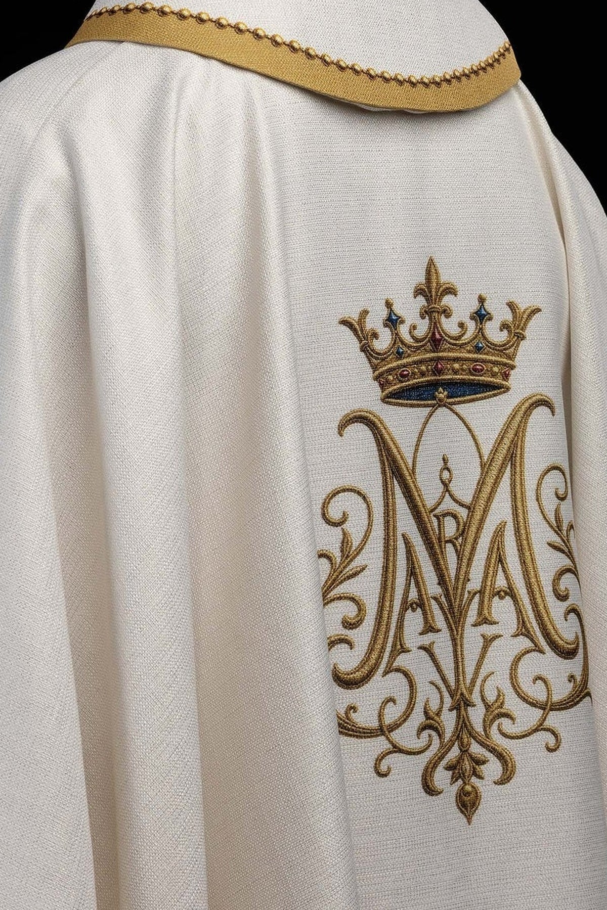 Biały ornat z haftowanym monogramem maryjnym pod koroną, zbliżenie tyłu