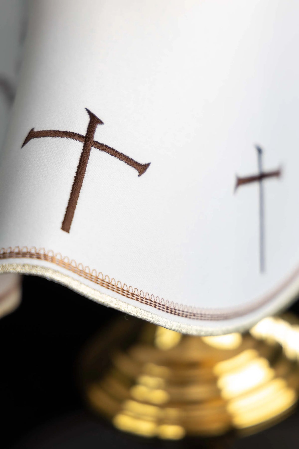 Biały welon franciszkański z haftowanym krzyżem, zbliżenie brzegu