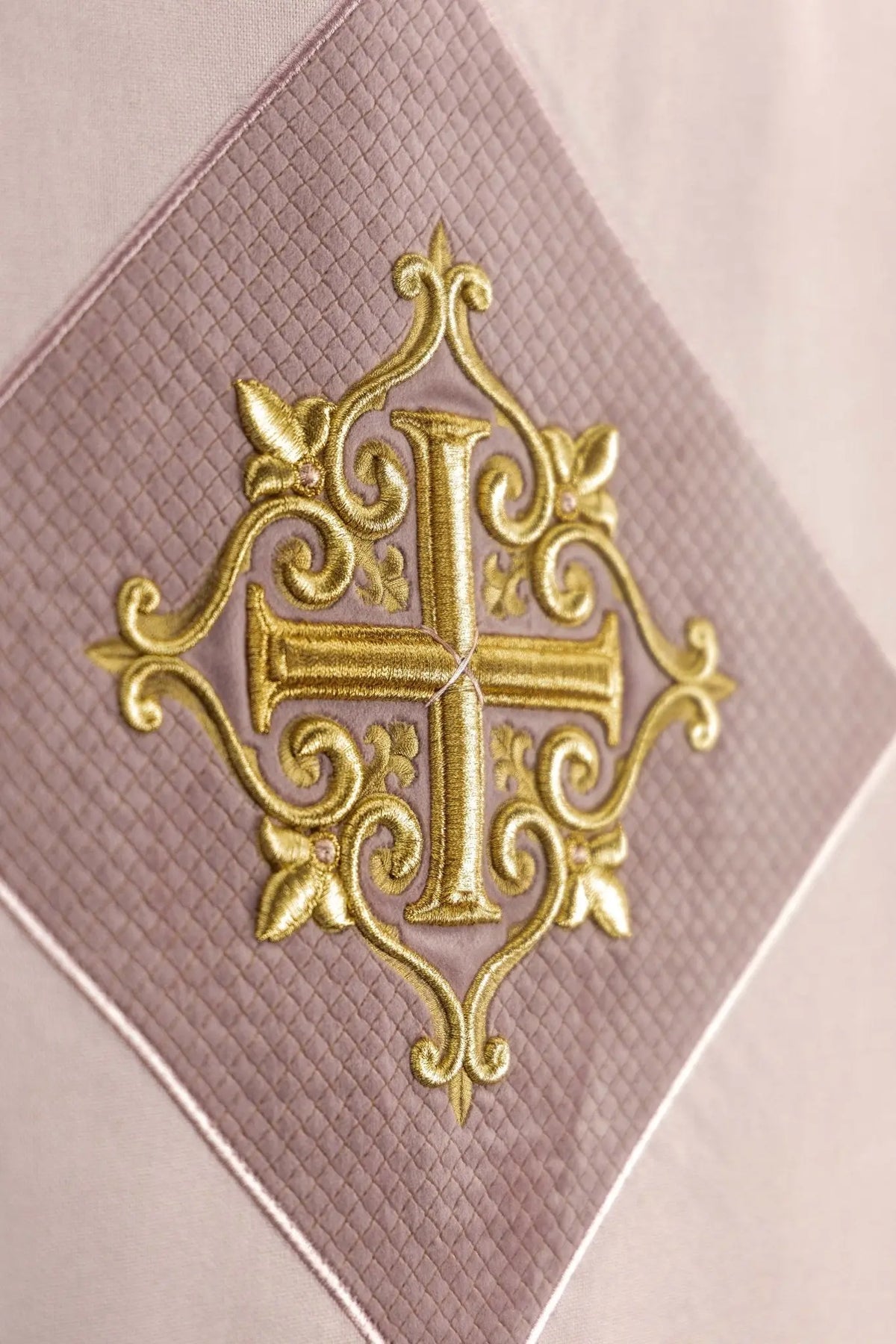 Różowa serweta na lektorium z haftem krzyża, zbliżenie haftu