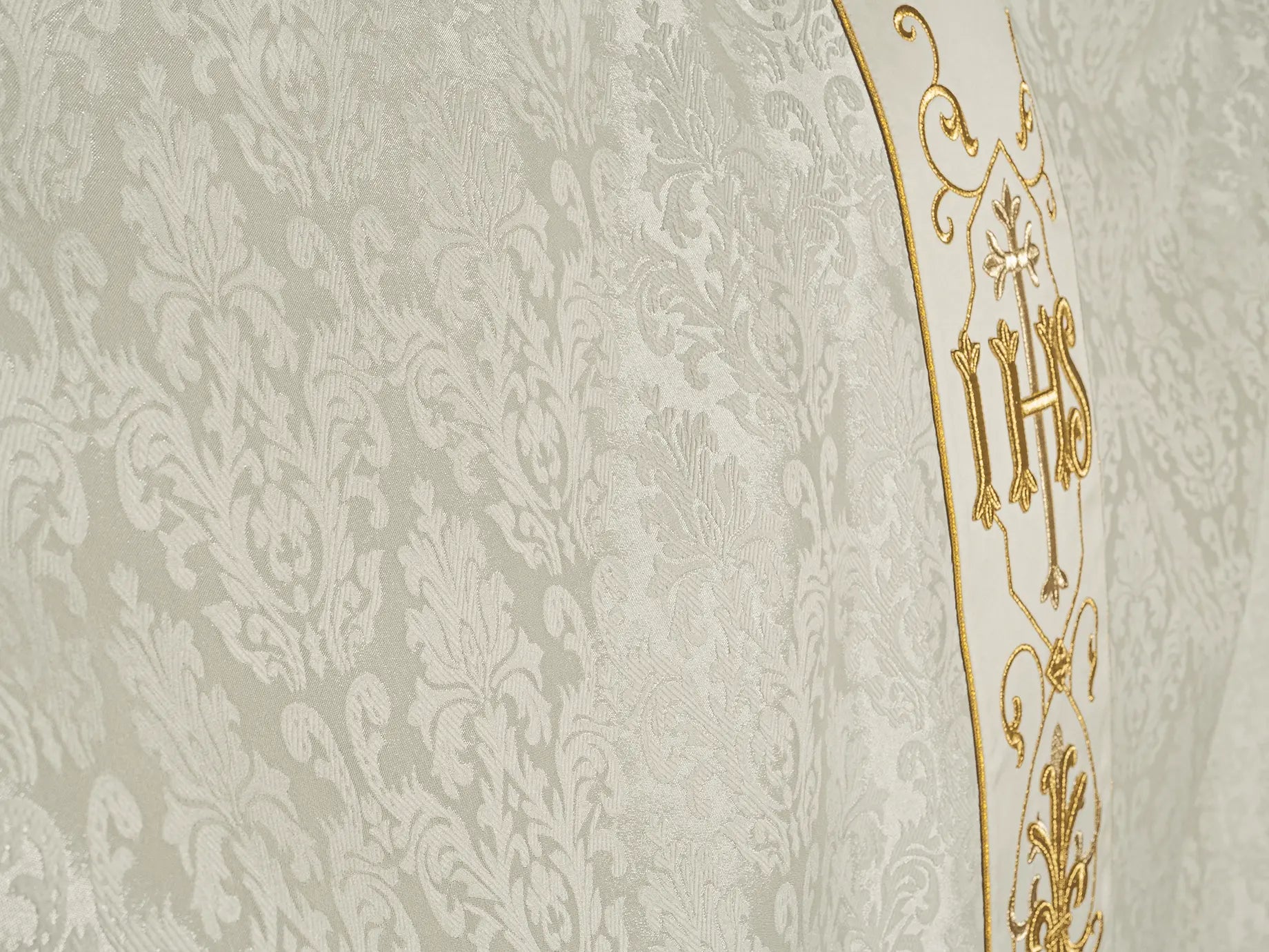 Ecru chasuble embroidered on decorative fabric with IHS symbol