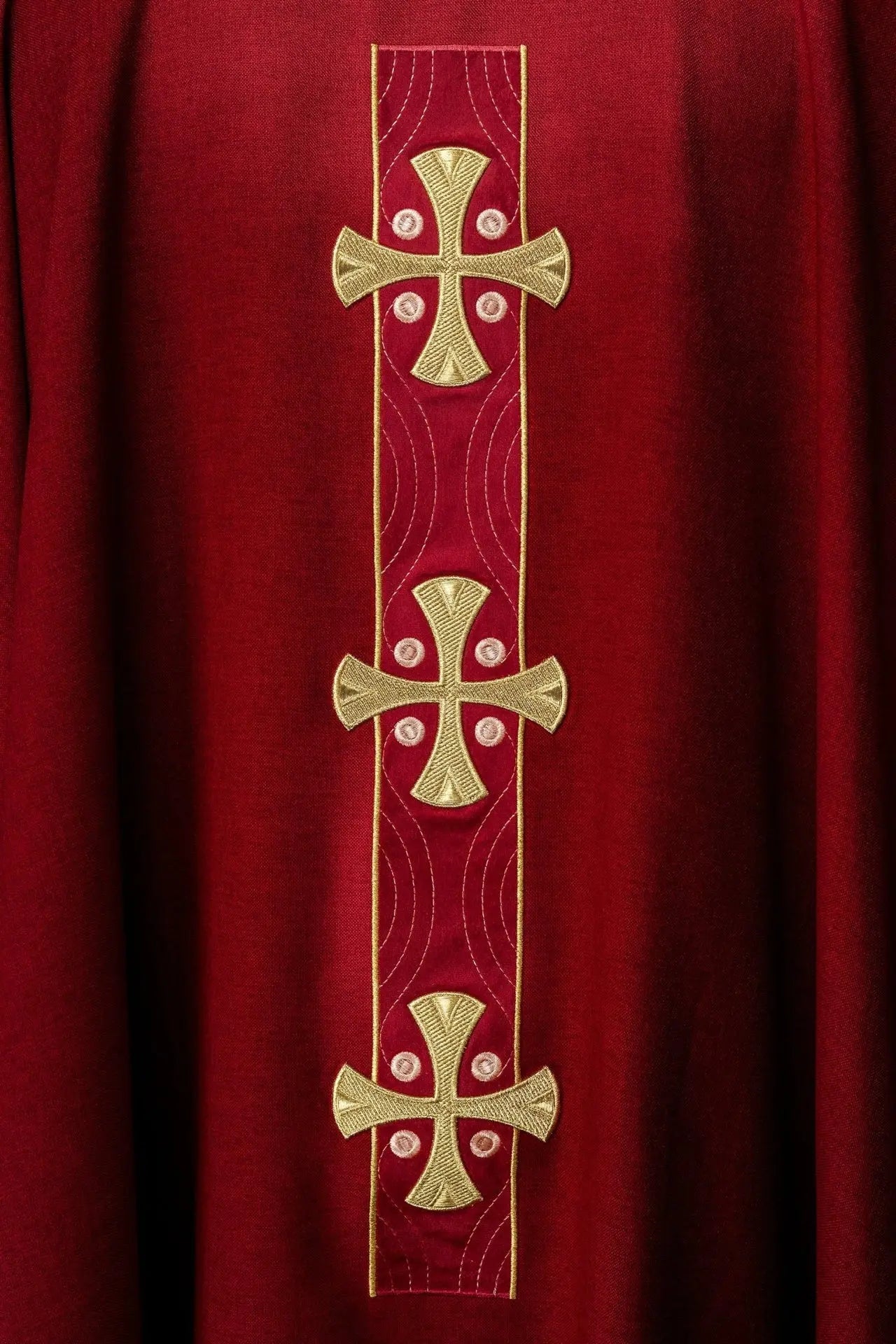 Ornat liturgiczny z haftowanymi złotymi krzyżami i wykończeniem kołnierza w czerwonym kolorze