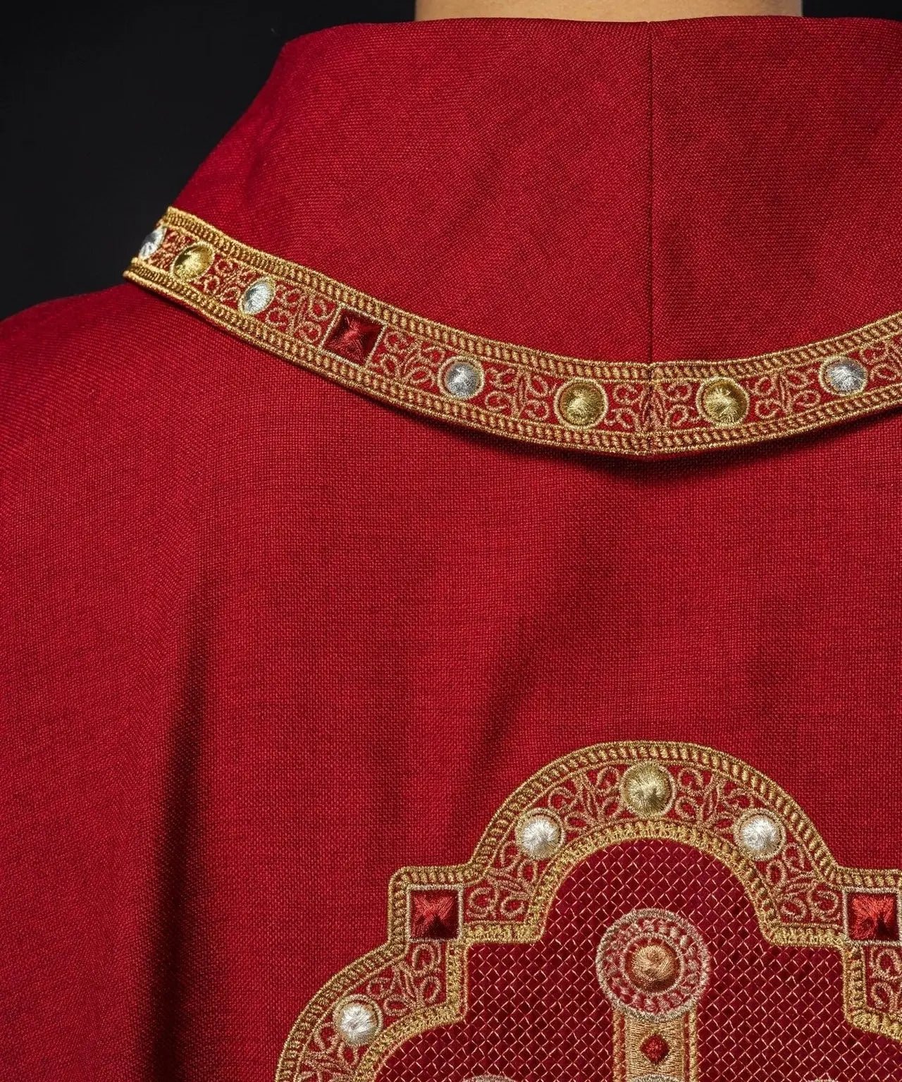 Ornat liturgiczny w czerwonym kolorze z haftowanym wykończeniem na kołnierzu i wokół haftu krzyża