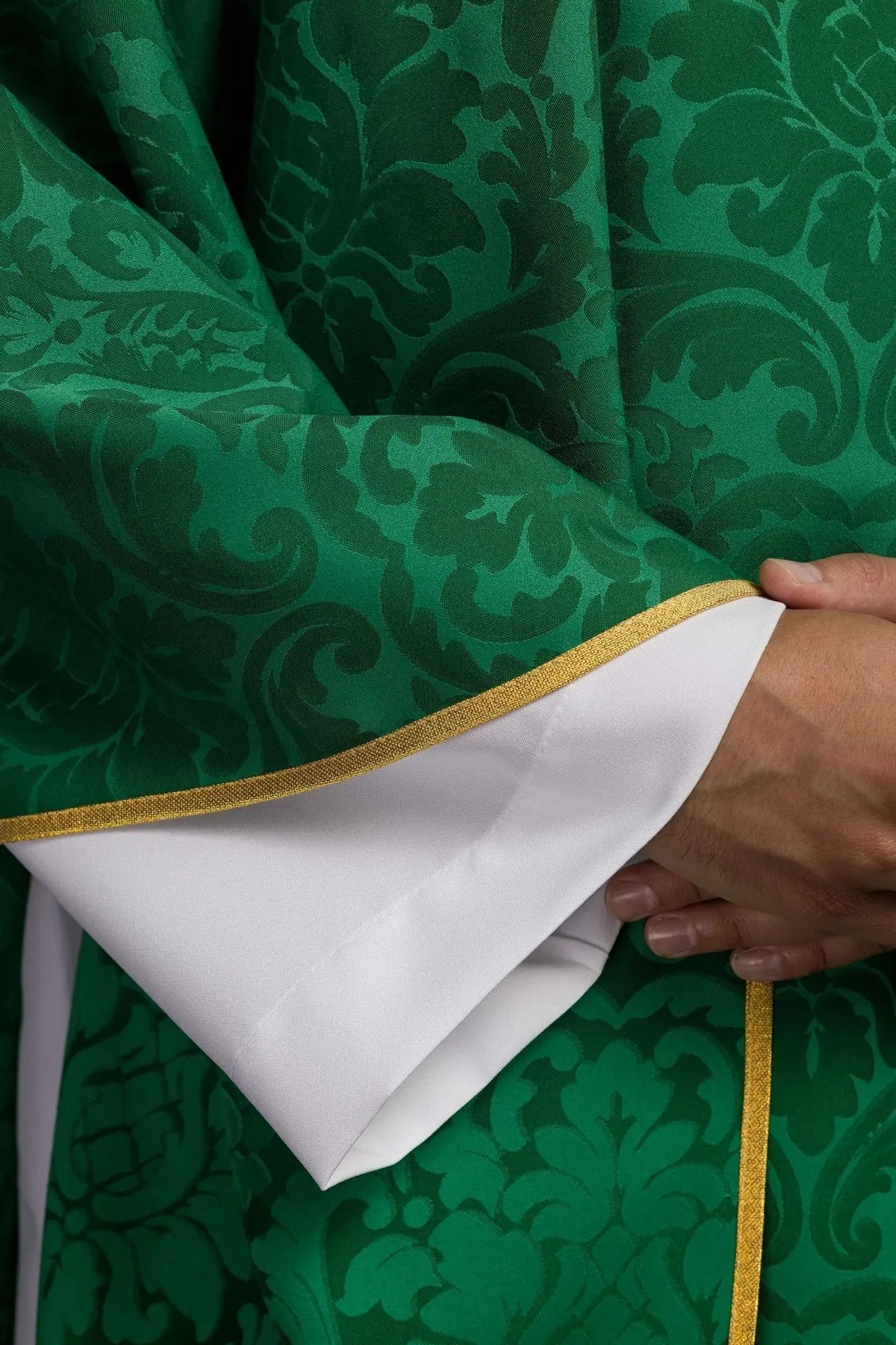 Green chasuble with IHS motif and richly embroidered collar on decorative fabric