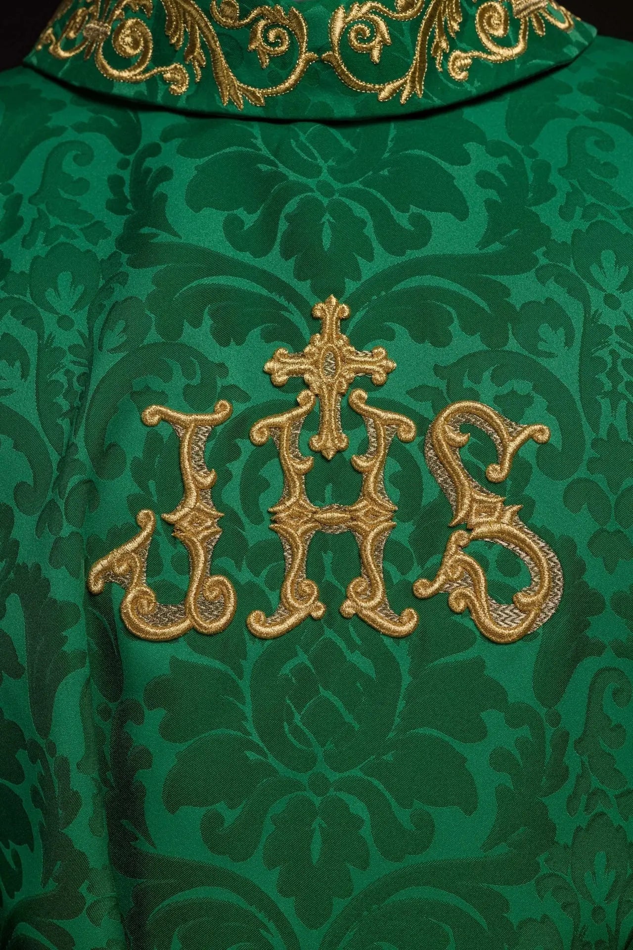 Green chasuble with IHS motif and richly embroidered collar on decorative fabric