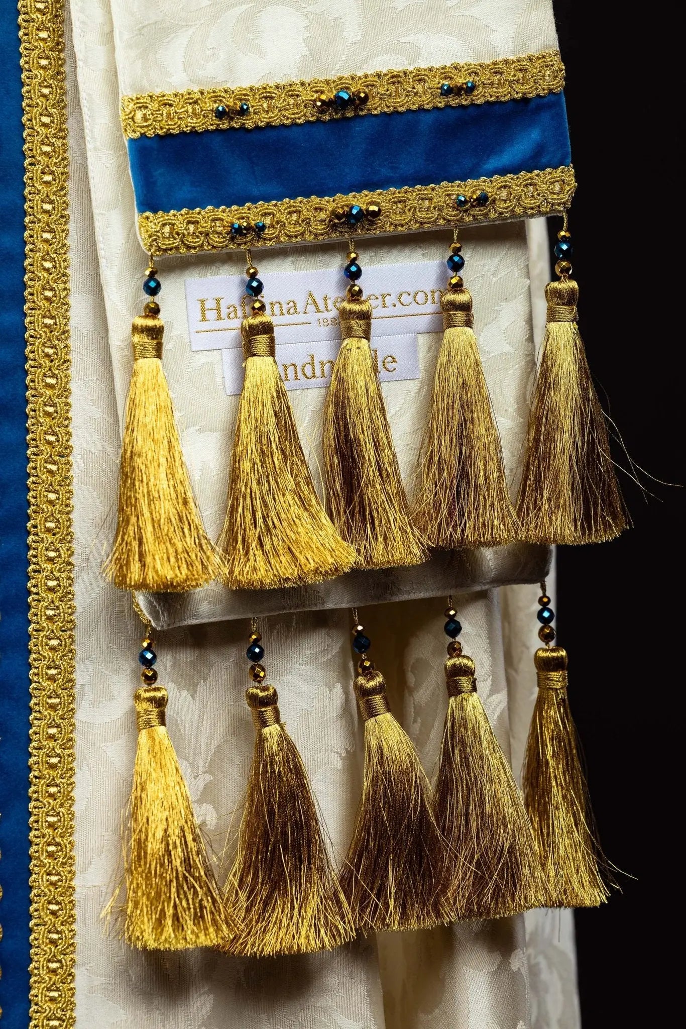 Ecru Marian cope with natural stones and blue velvet trim, part of the Handmade Collection, featuring an ornate metal clasp and gold tassel.