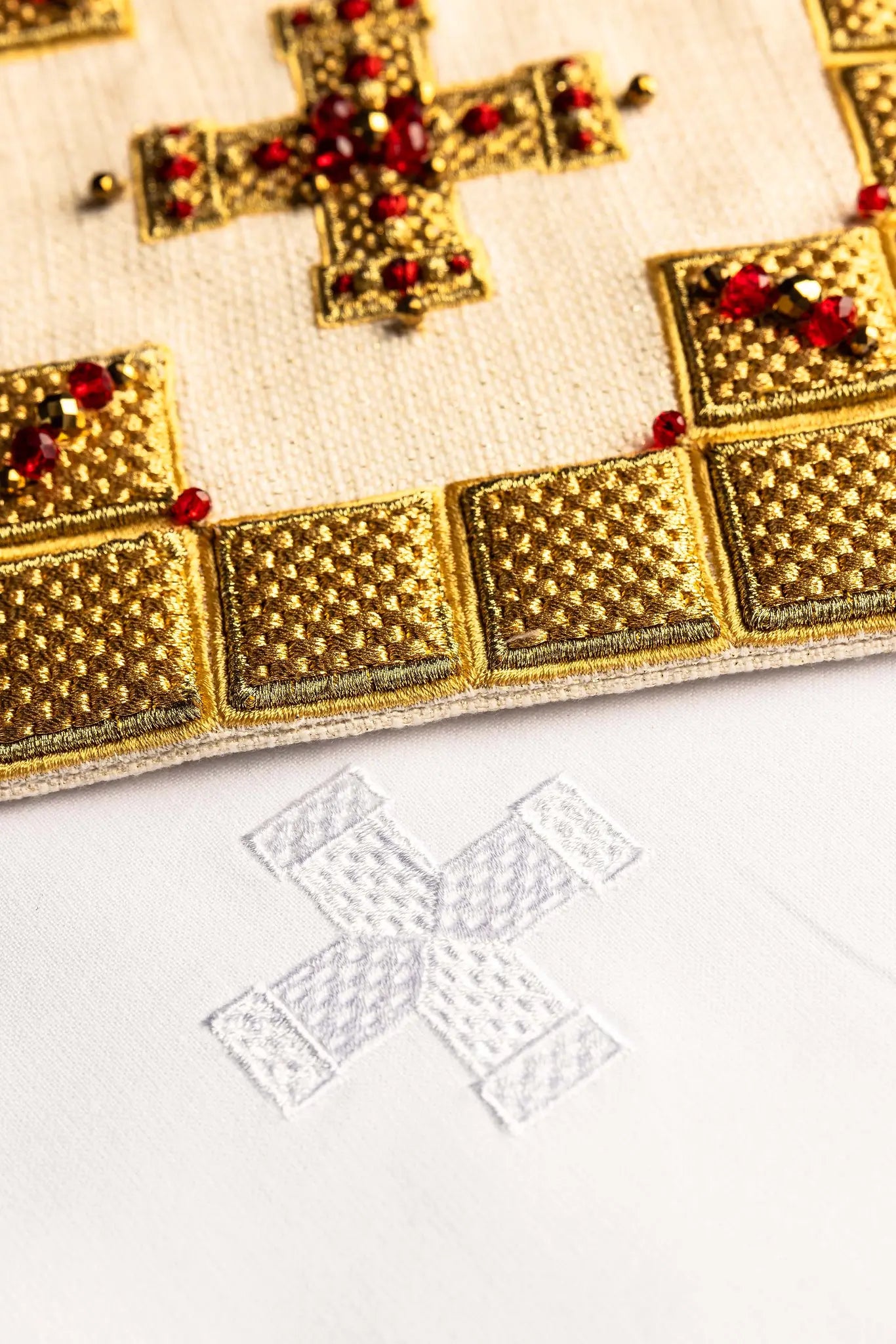 Ecru handmade chalice linen set with a pall featuring a dimensional gold cross, red hematite, and shimmering crystals, a corporal with a central cross, and a purificator and lavabo towel with embroidered crosses, all with scalloped edges.
