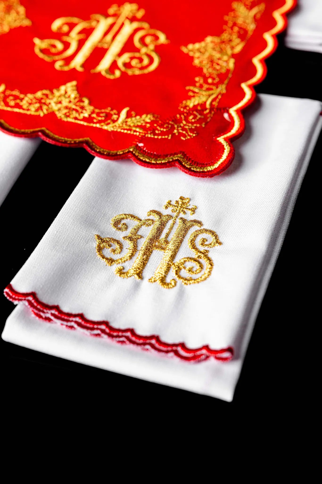 Red chalice linen set with gold IHS embroidery, including a pall, corporal, purificator, and lavabo towel.
