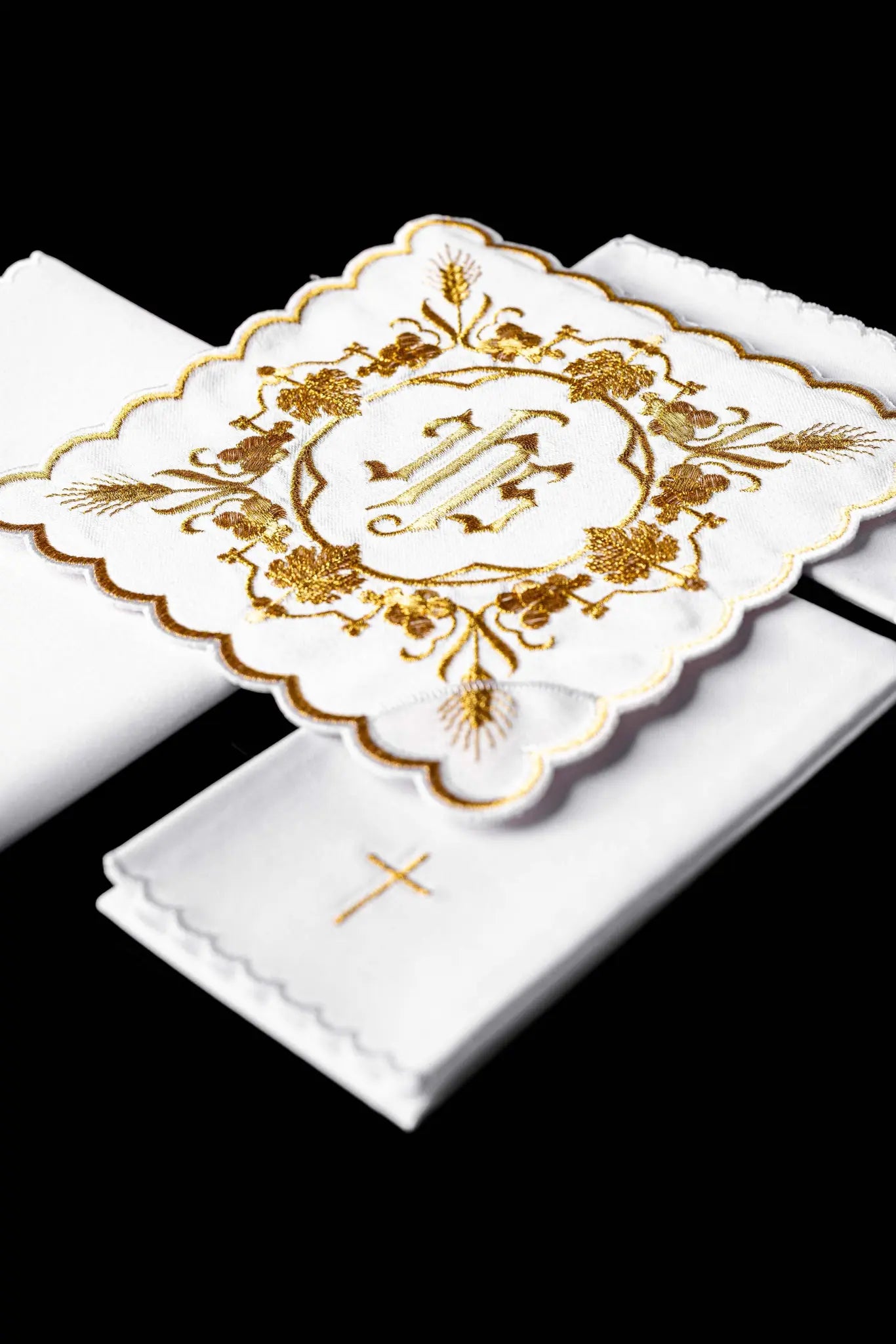 White chalice linen set with IHS embroidery on pall, purificator, and lavabo towel.
