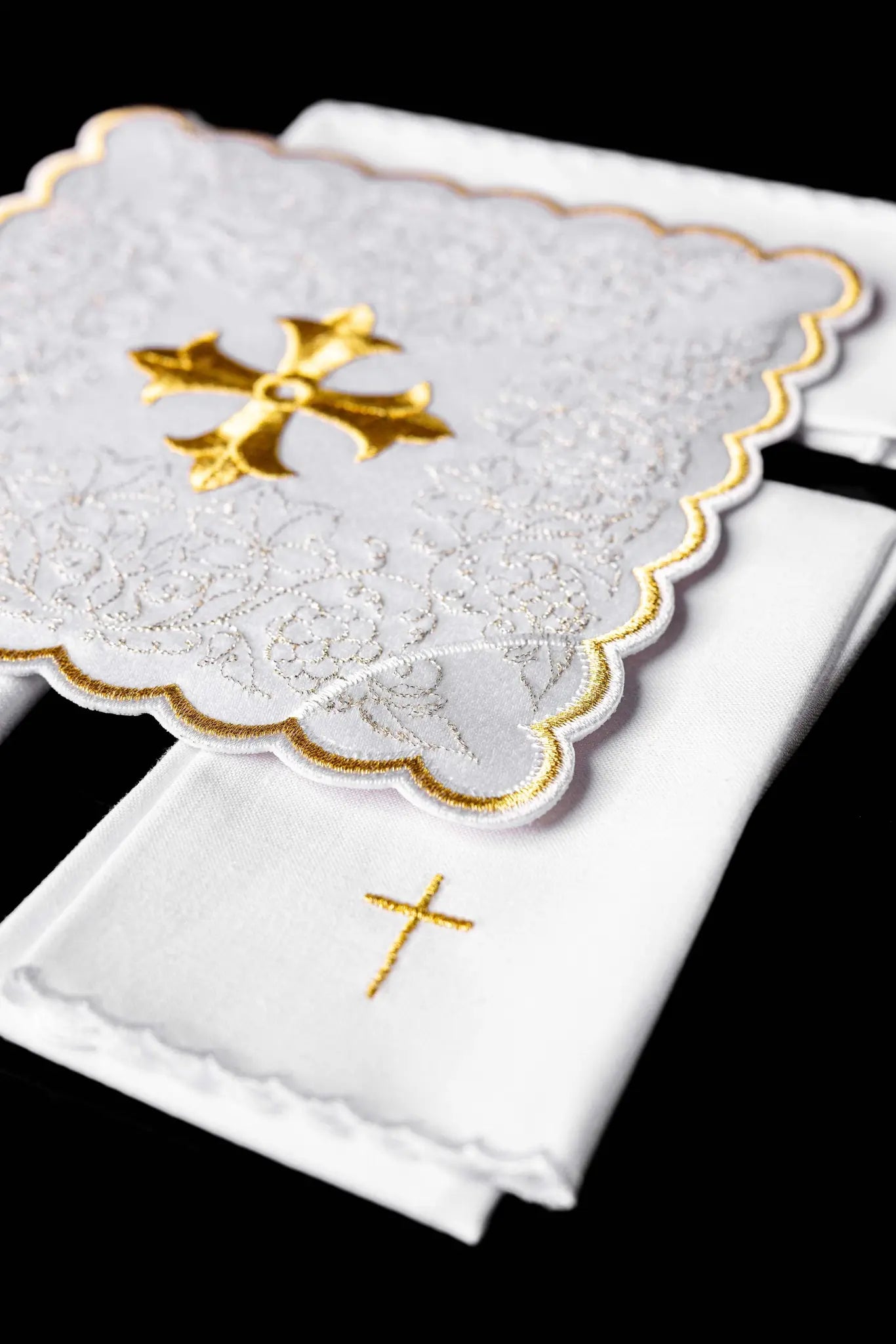 White chalice linen set with gold embroidered cross motif, including pall, corporal, purificator, and lavabo towel.