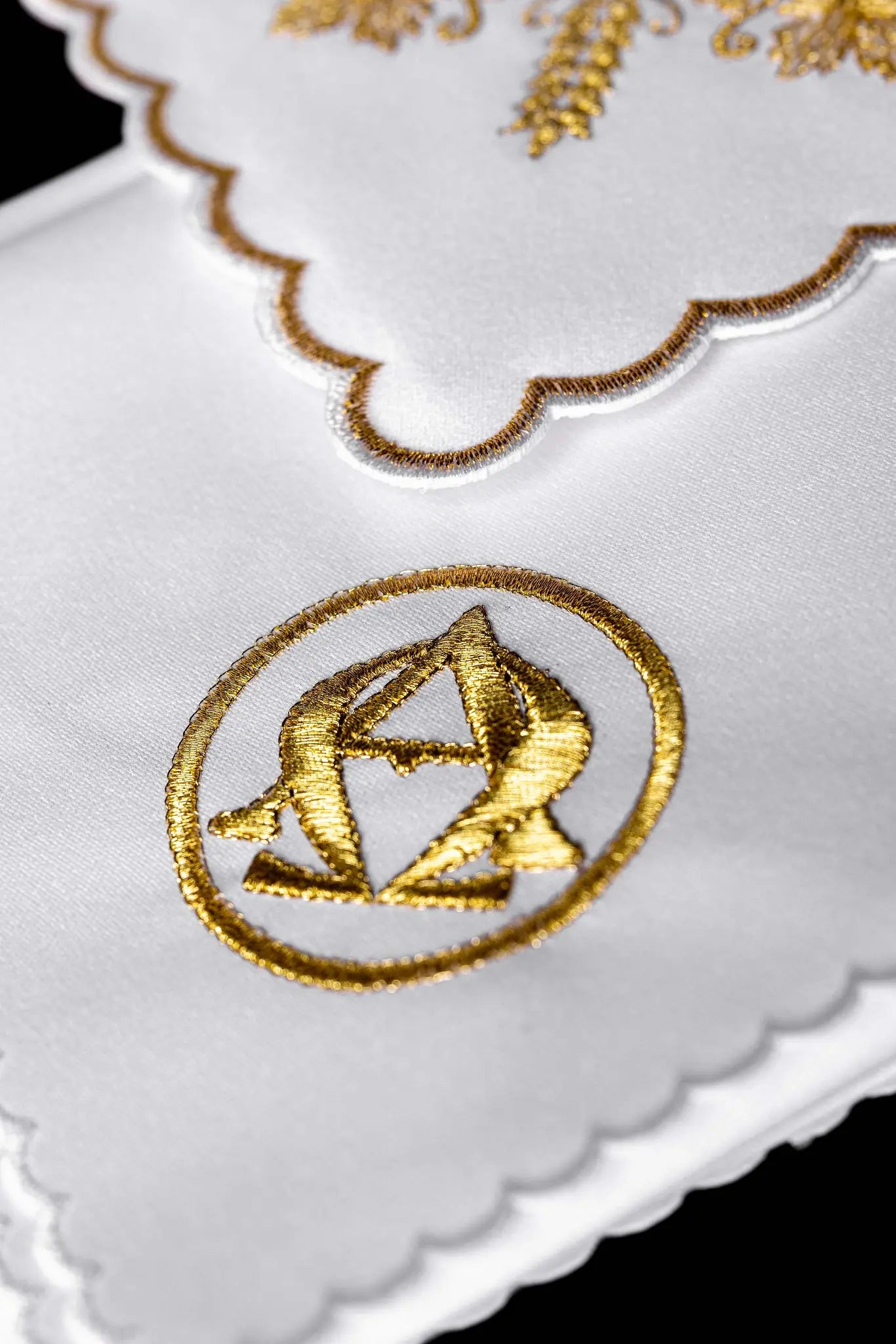 White chalice linen set with gold Alpha and Omega embroidery, including pall, corporal, purificator, and lavabo towel.
