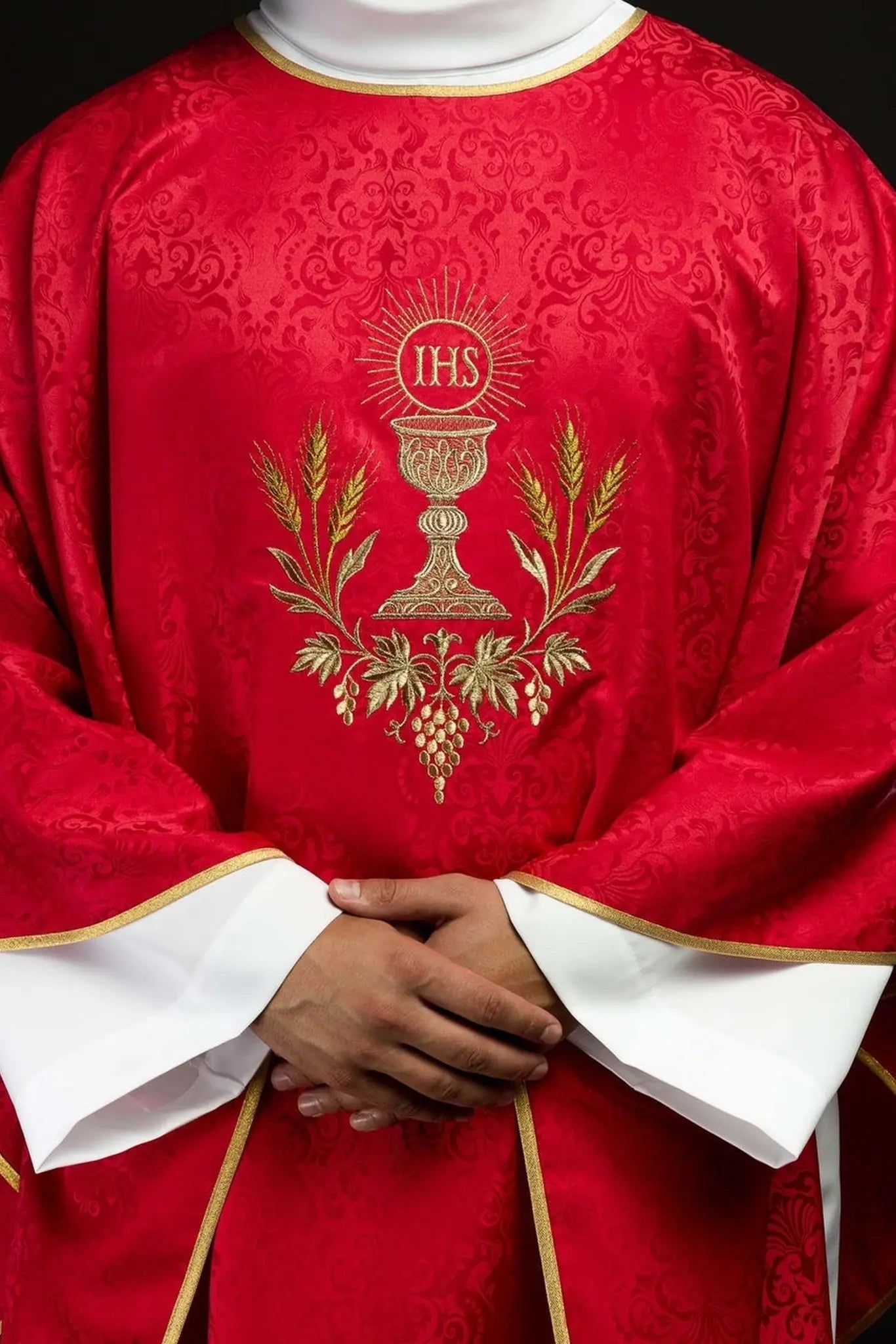 Czerwony ornat liturgiczny z haftowanym kielichem i hostią na tkaninie żakardowej