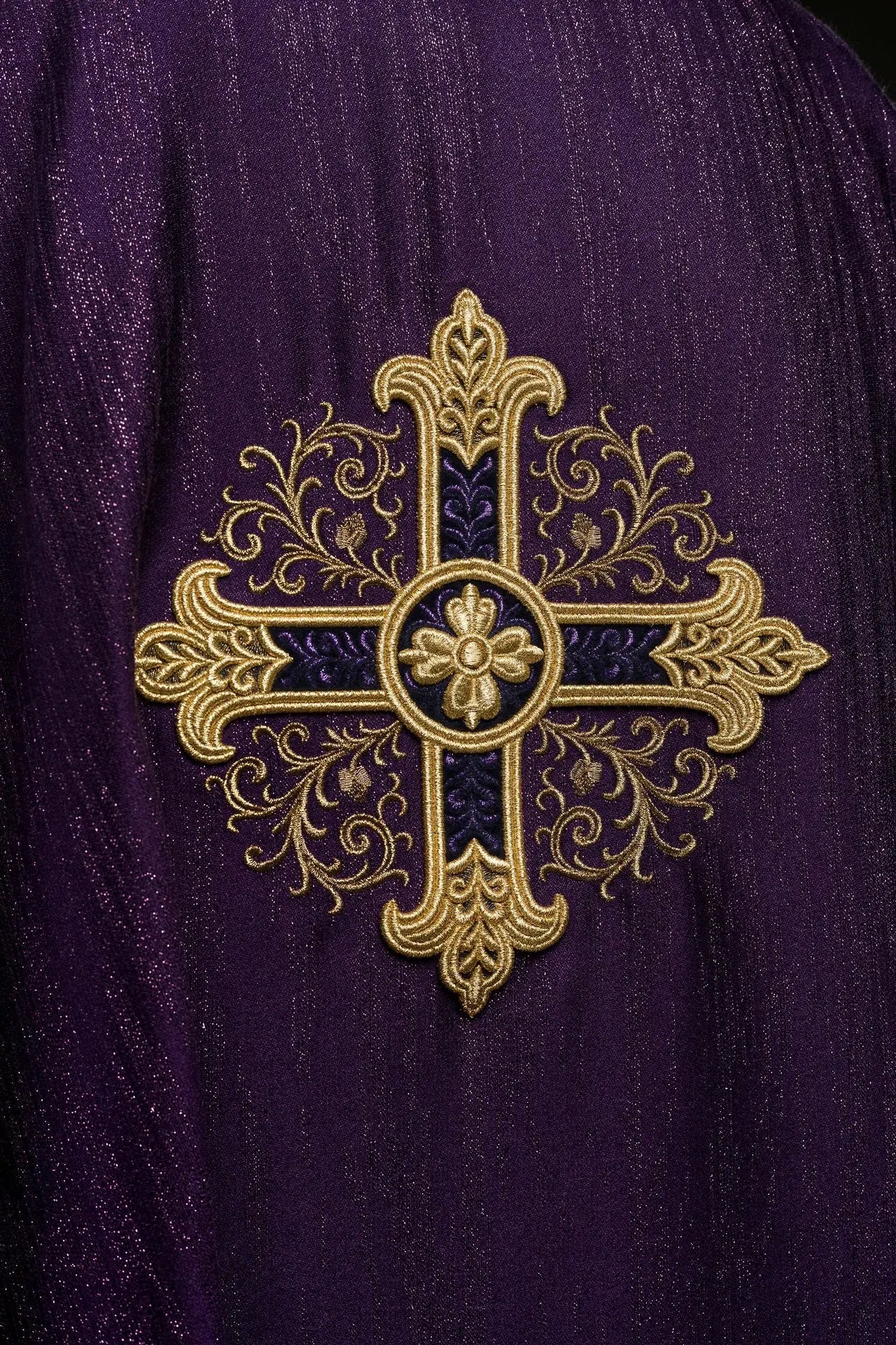 Ornat liturgiczny w kolorze fioletowym z haftowanym motywem krzyża na ozdobnej tkaninie 