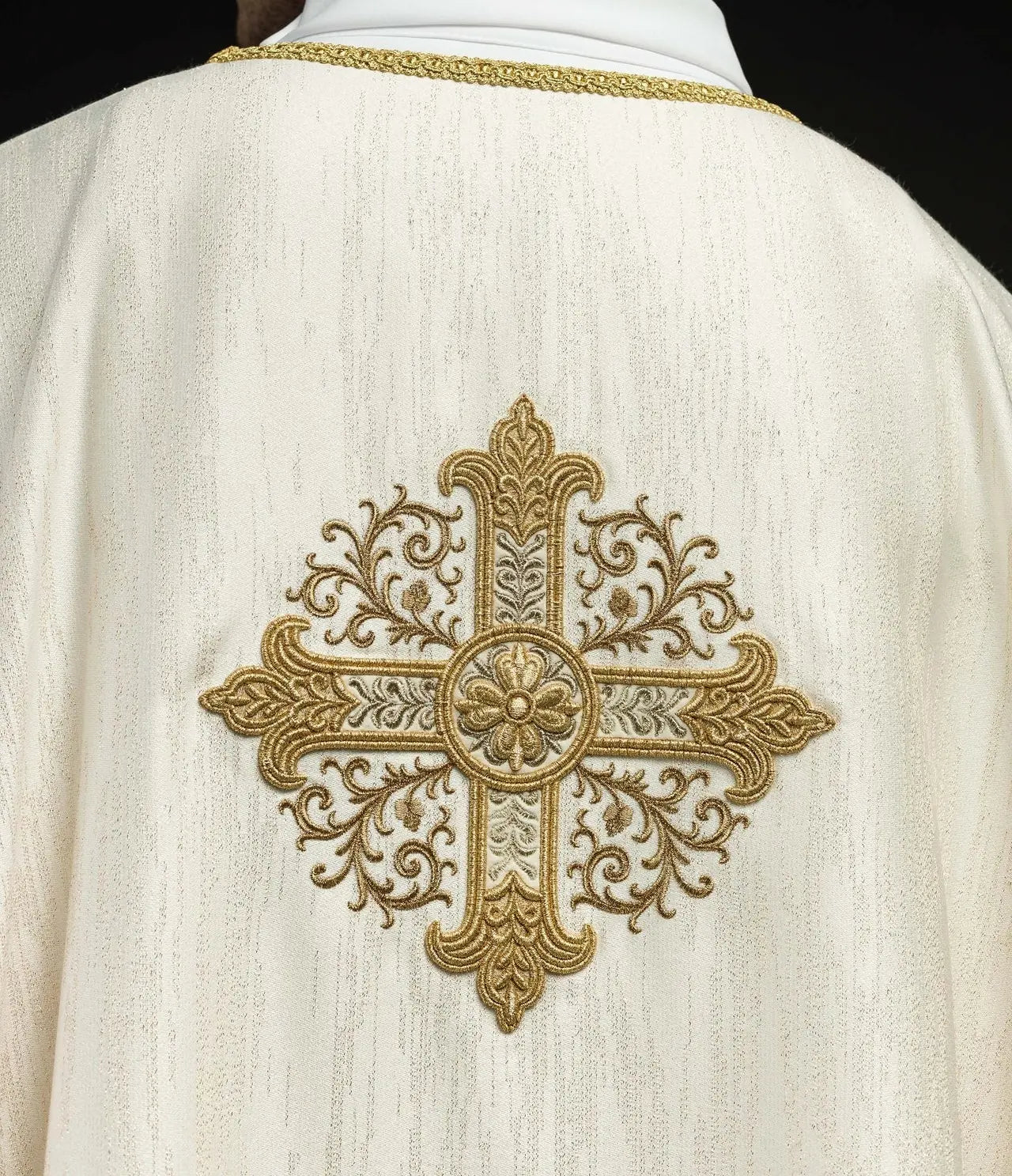 Ecru chasuble with embroidered cross motif on decorative fabric