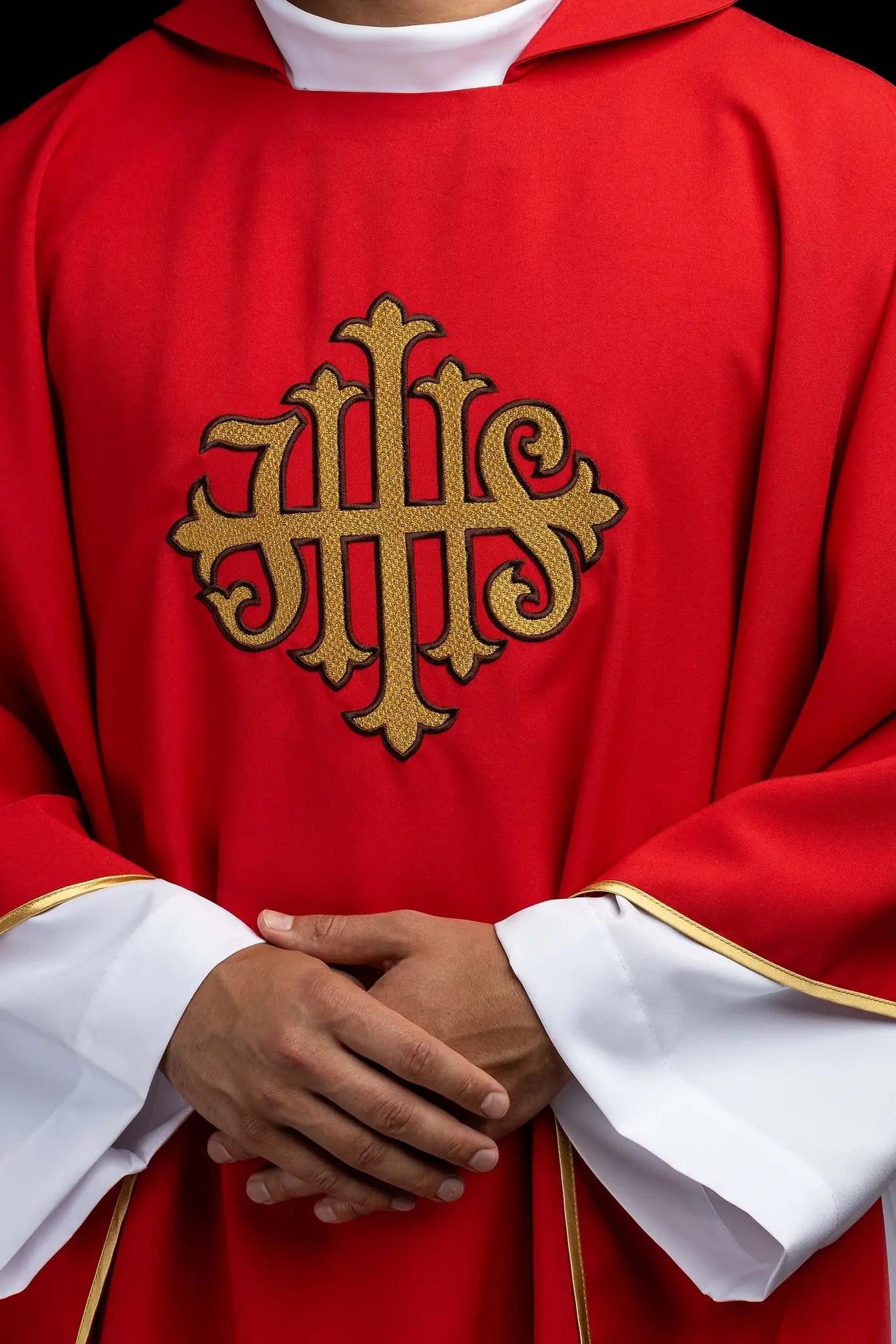 Red chasuble with gold IHS embroidery on the front and back, finished with gold trim and a V-neckline.