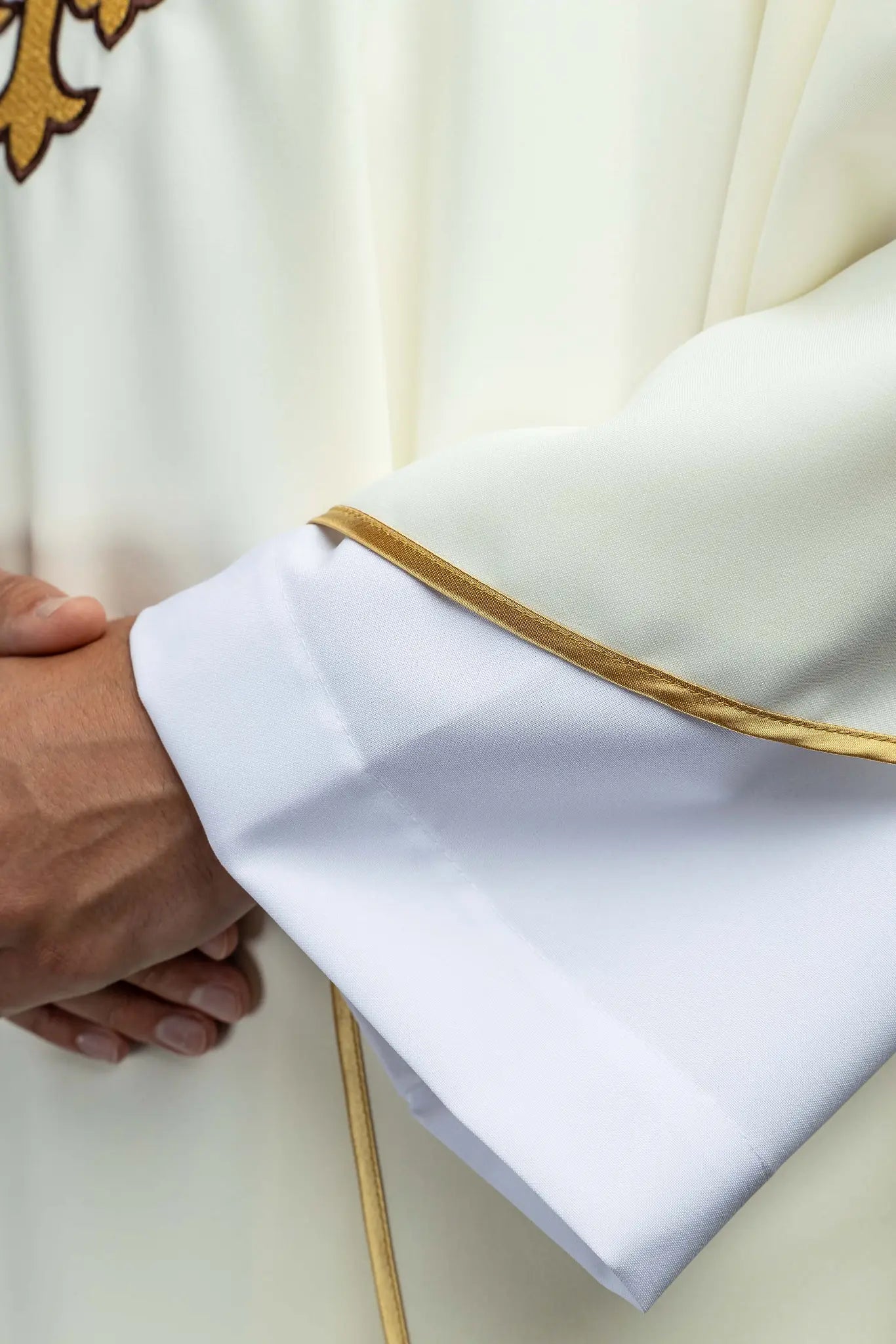Ecru chasuble with gold IHS embroidery and gold trim, featuring a V-neck collar.