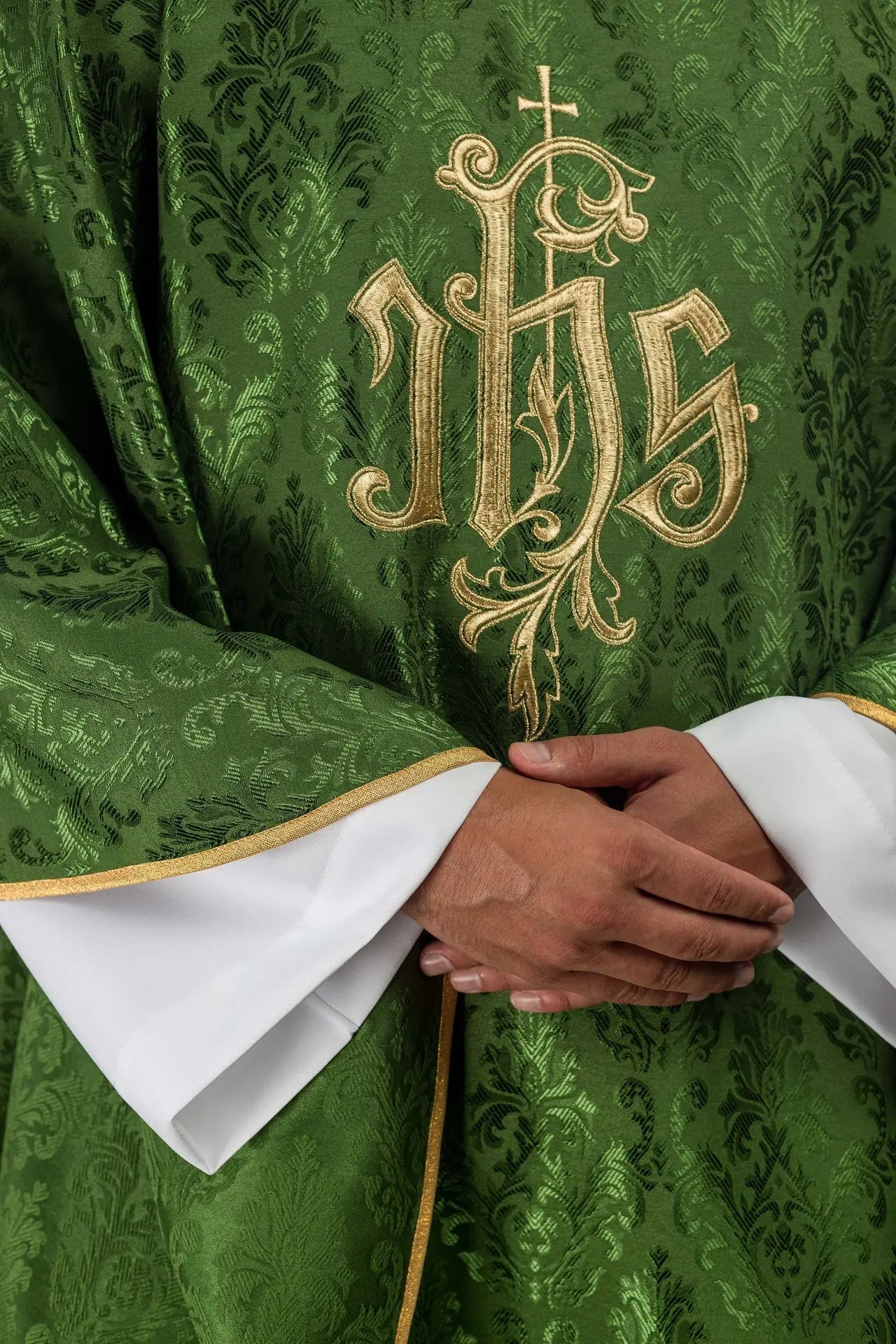 Zielony ornat liturgiczny z haftowanym motywem IHS na ozdobnej tkaninie