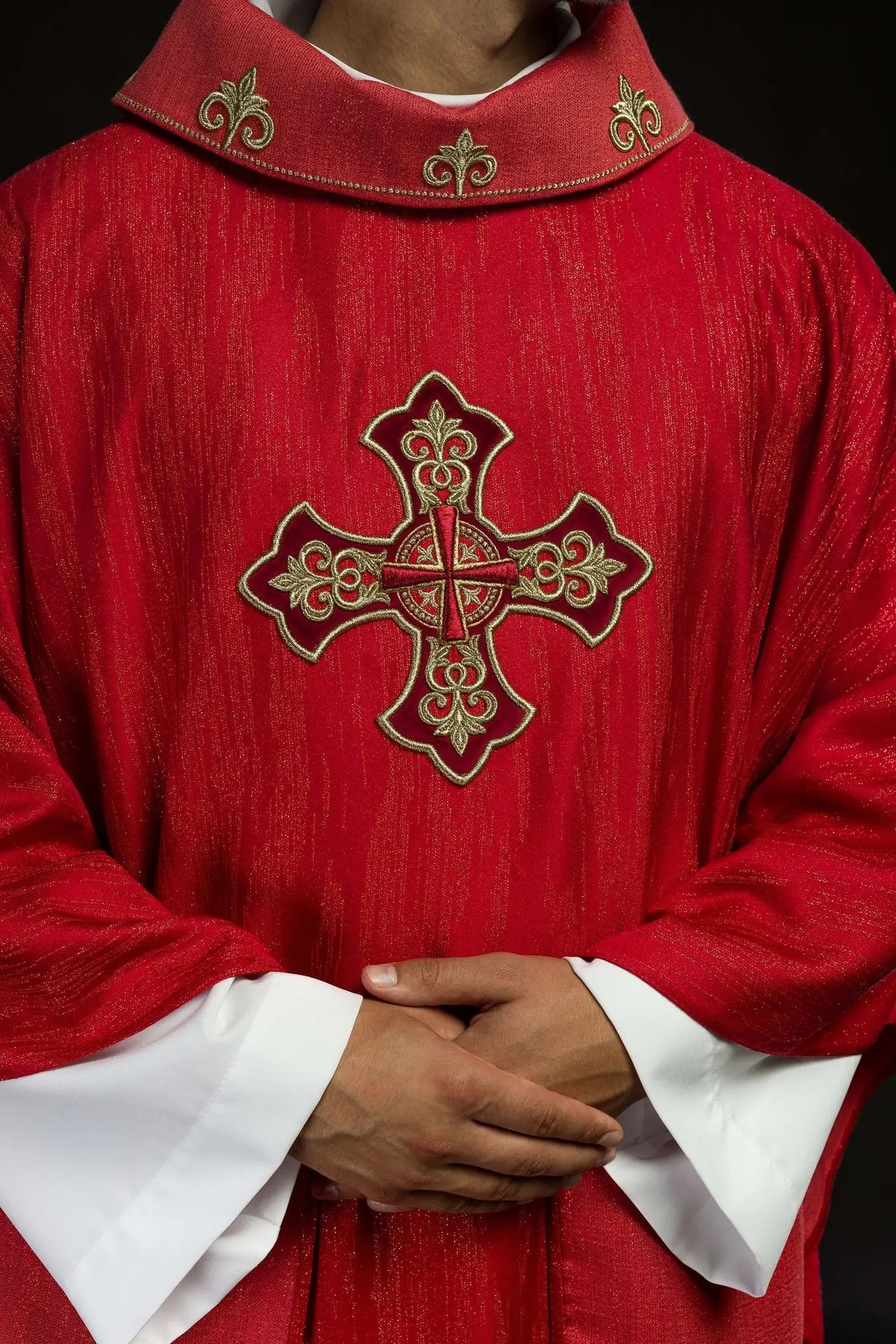 Czerwony ornat z haftowanym motywem krzyża na dekoracyjnej tkaninie