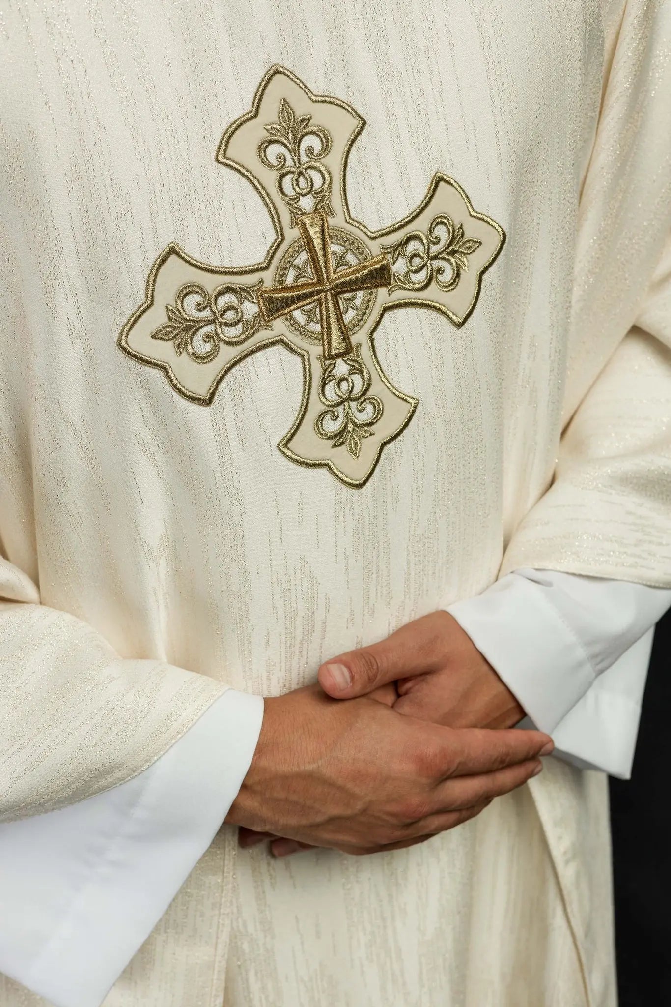 Ornat liturgiczny w kolorze ecru z haftowanym motywem krzyża na ozdobnej tkaninie 