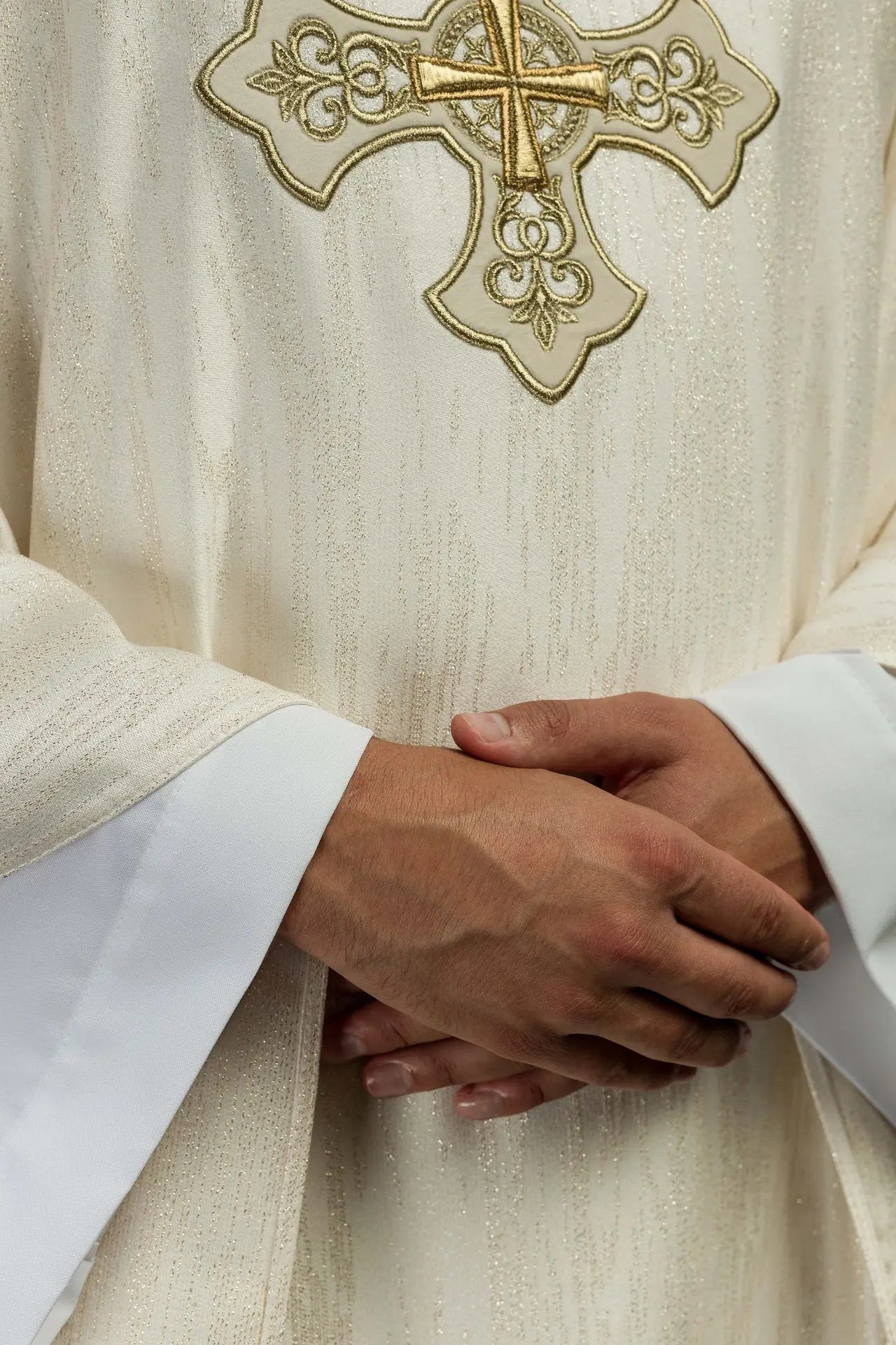 Ornat liturgiczny w kolorze ecru z haftowanym motywem krzyża na ozdobnej tkaninie 