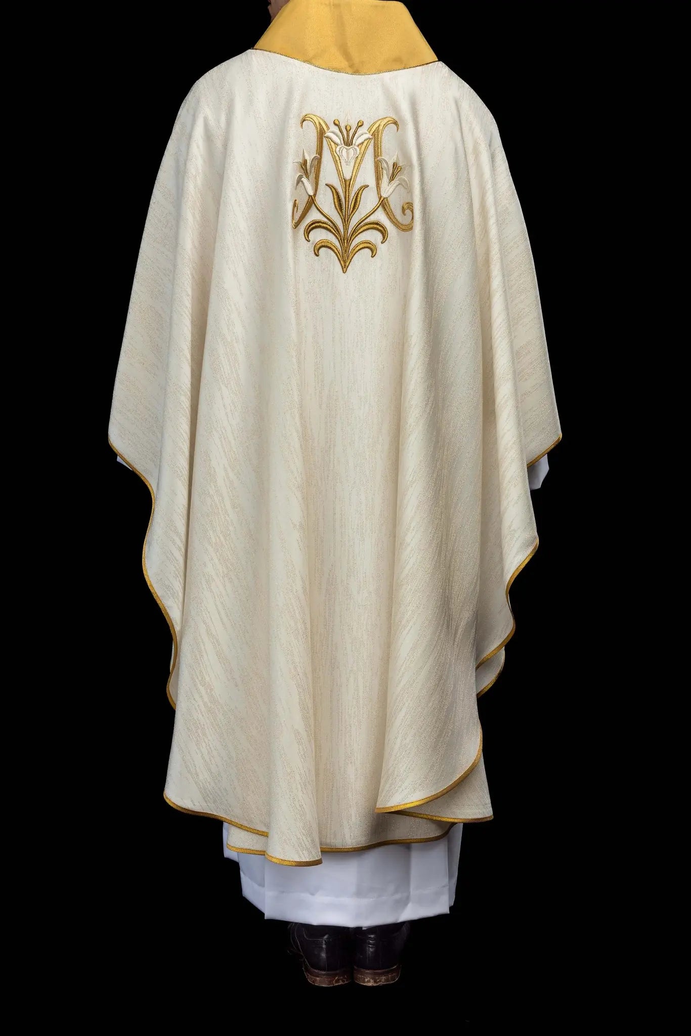 Ecru chasuble with Marian lily embroidery, gold collar, and gold trim.