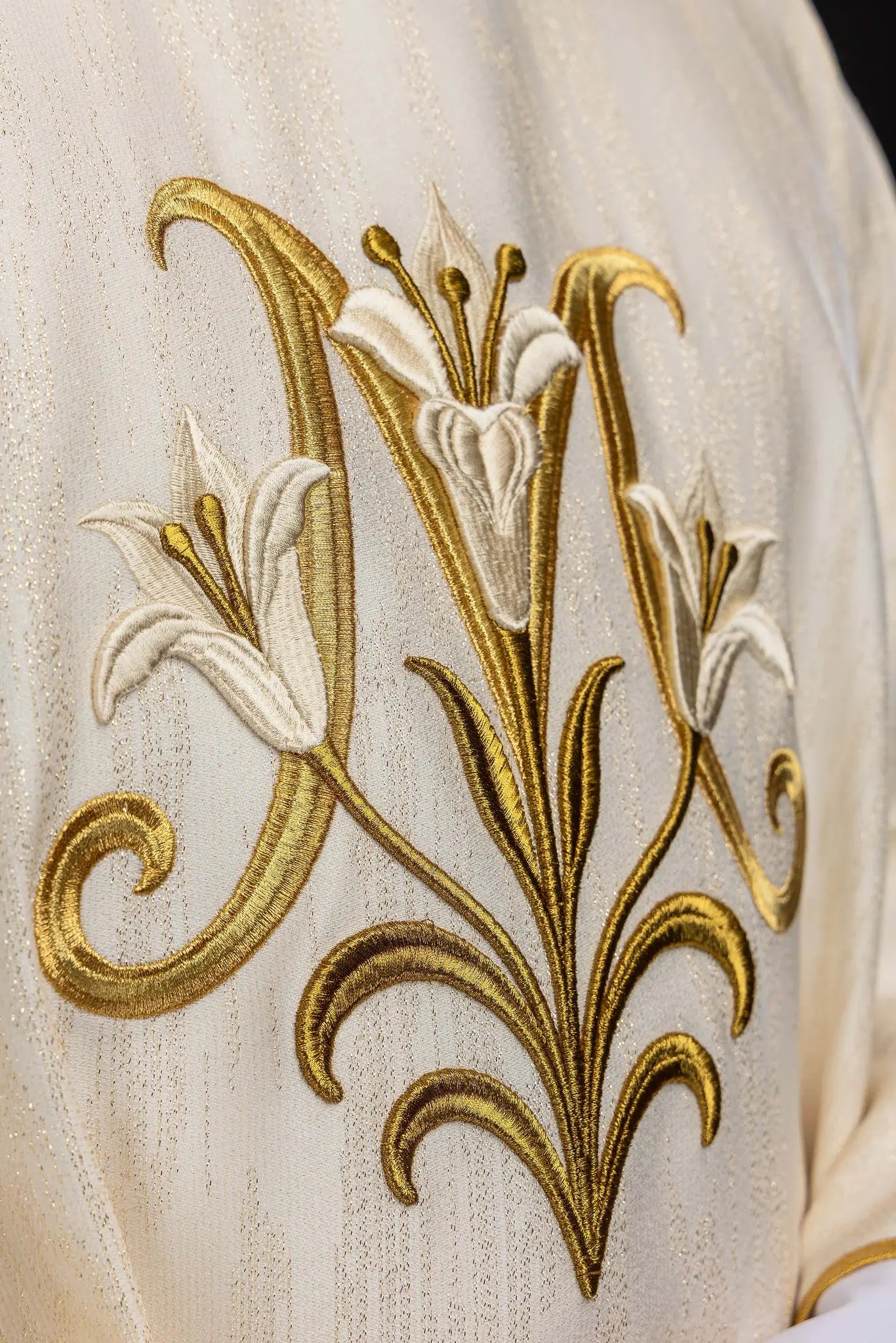 Ecru chasuble with Marian lily embroidery, gold collar, and gold trim.