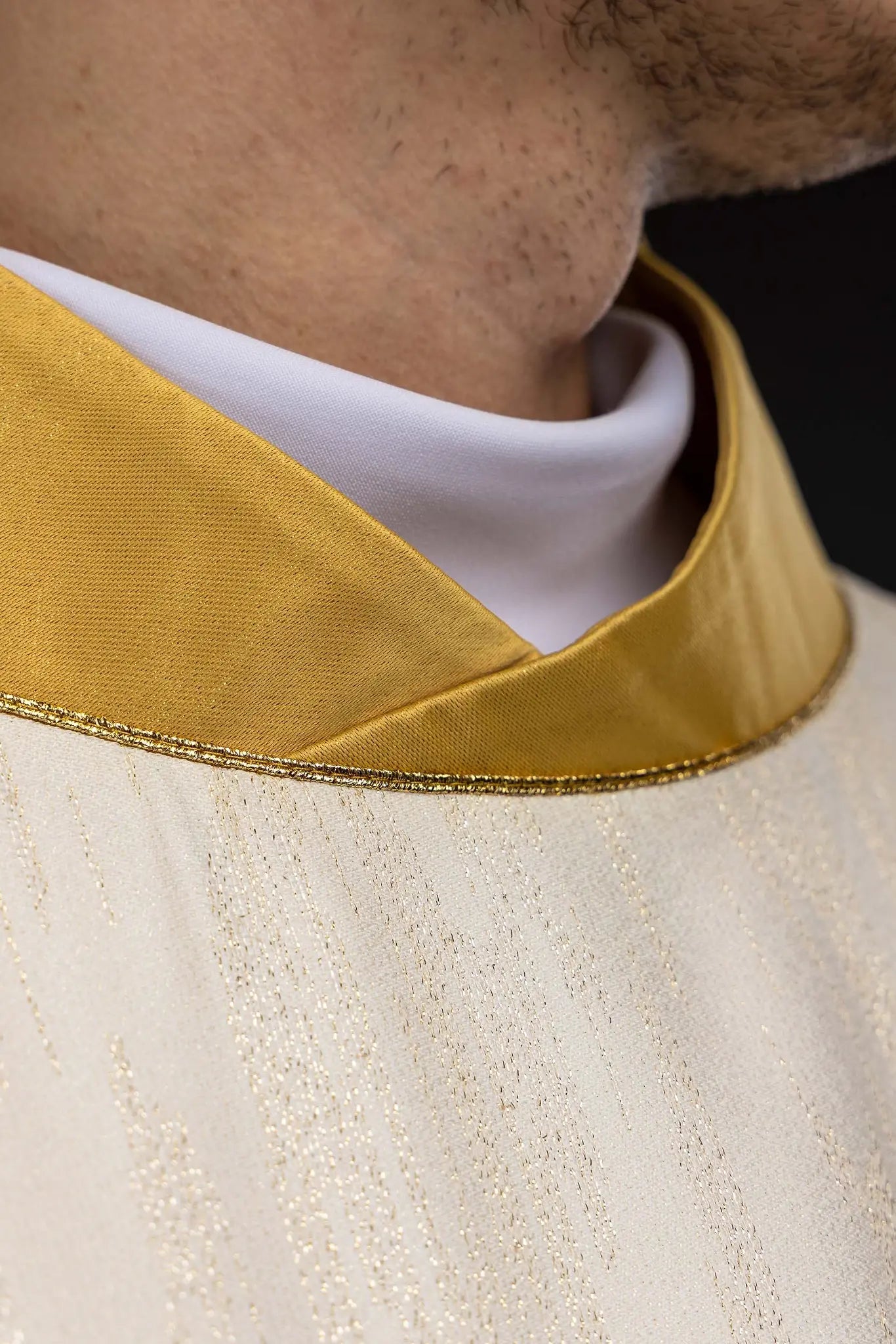 Ecru chasuble with Marian lily embroidery, gold collar, and gold trim.