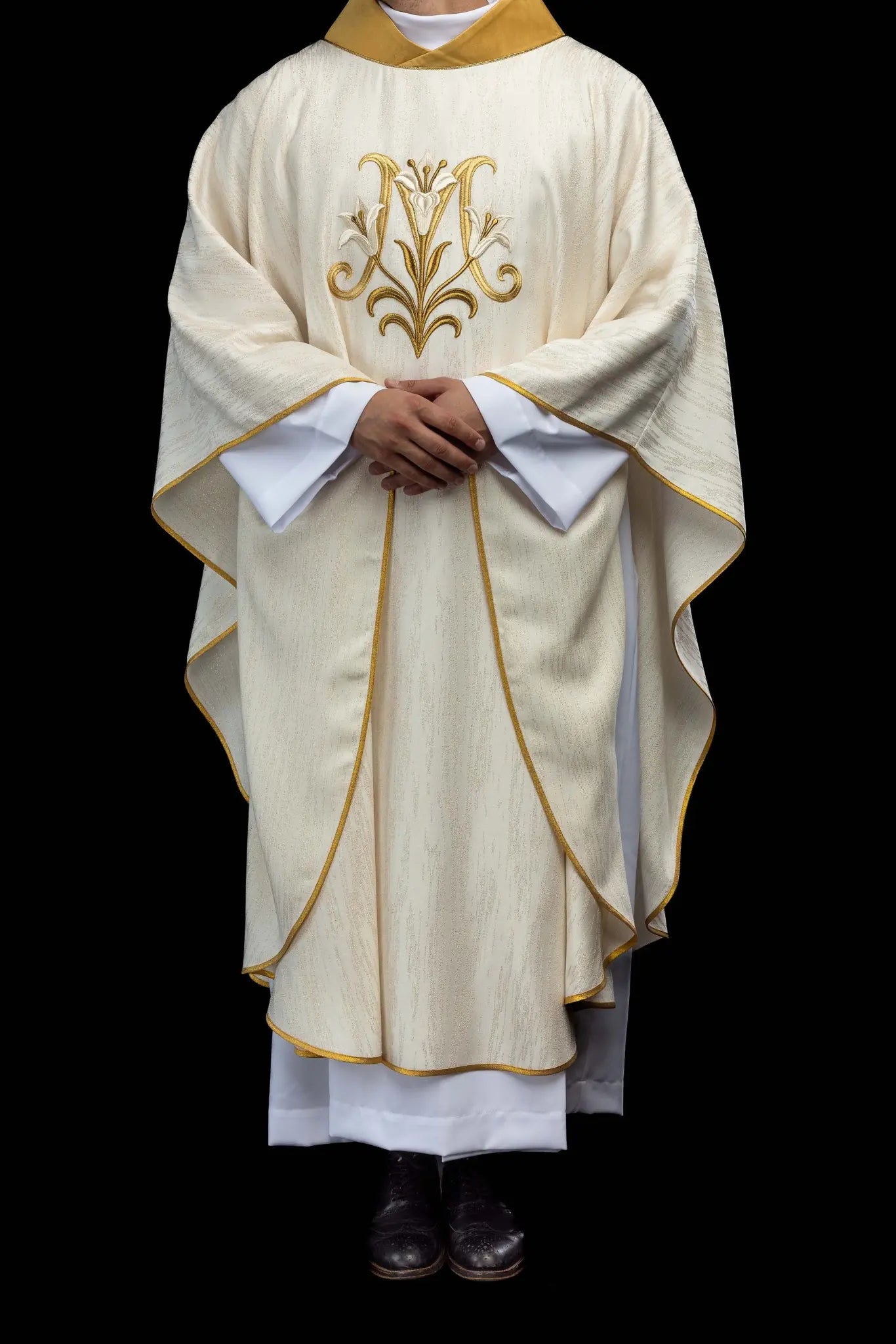 Ecru chasuble with Marian lily embroidery, gold collar, and gold trim.